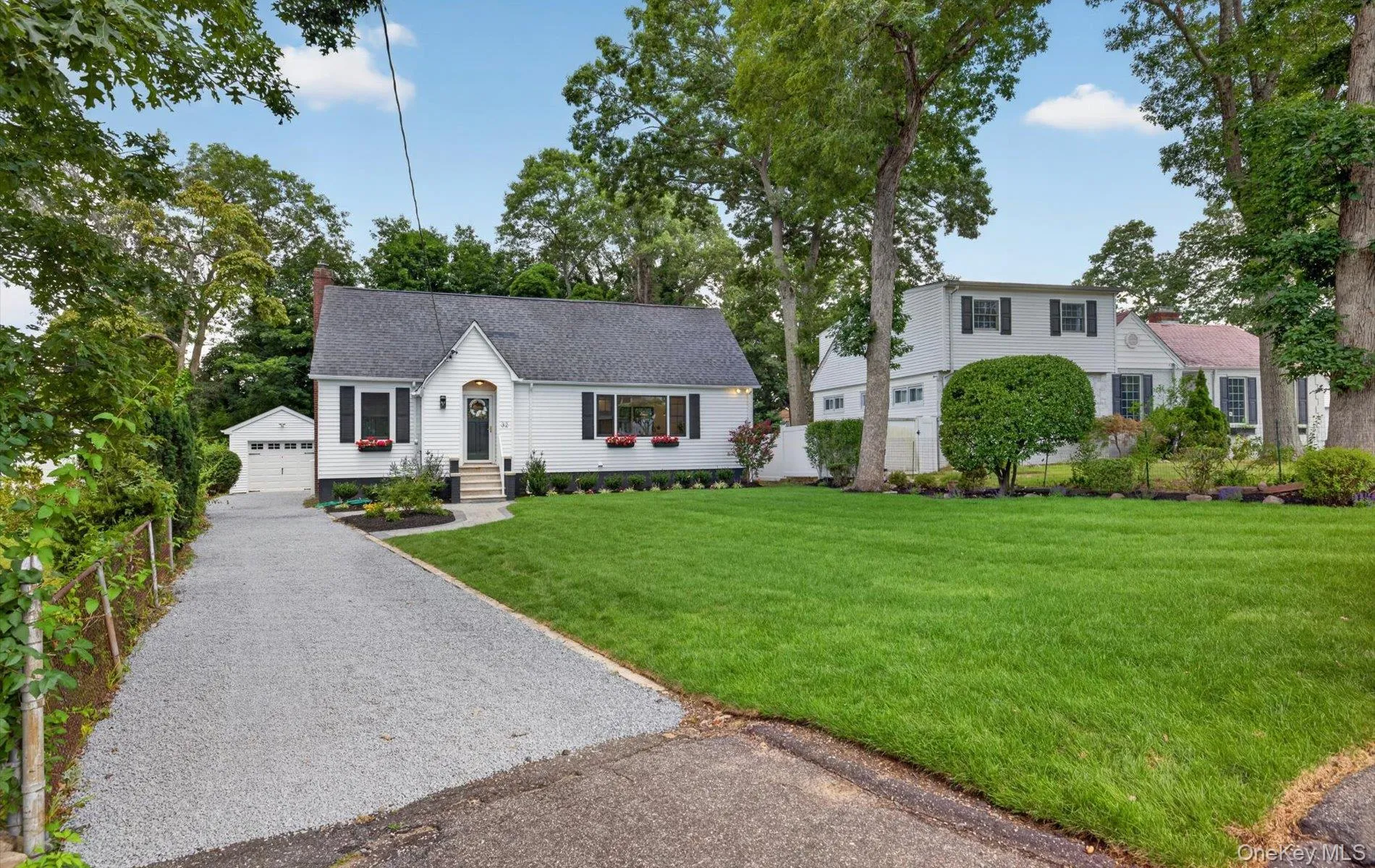 White exterior residence with a dark shingle roof and black shutters White exterior residence with a dark shingle roof and black shutters