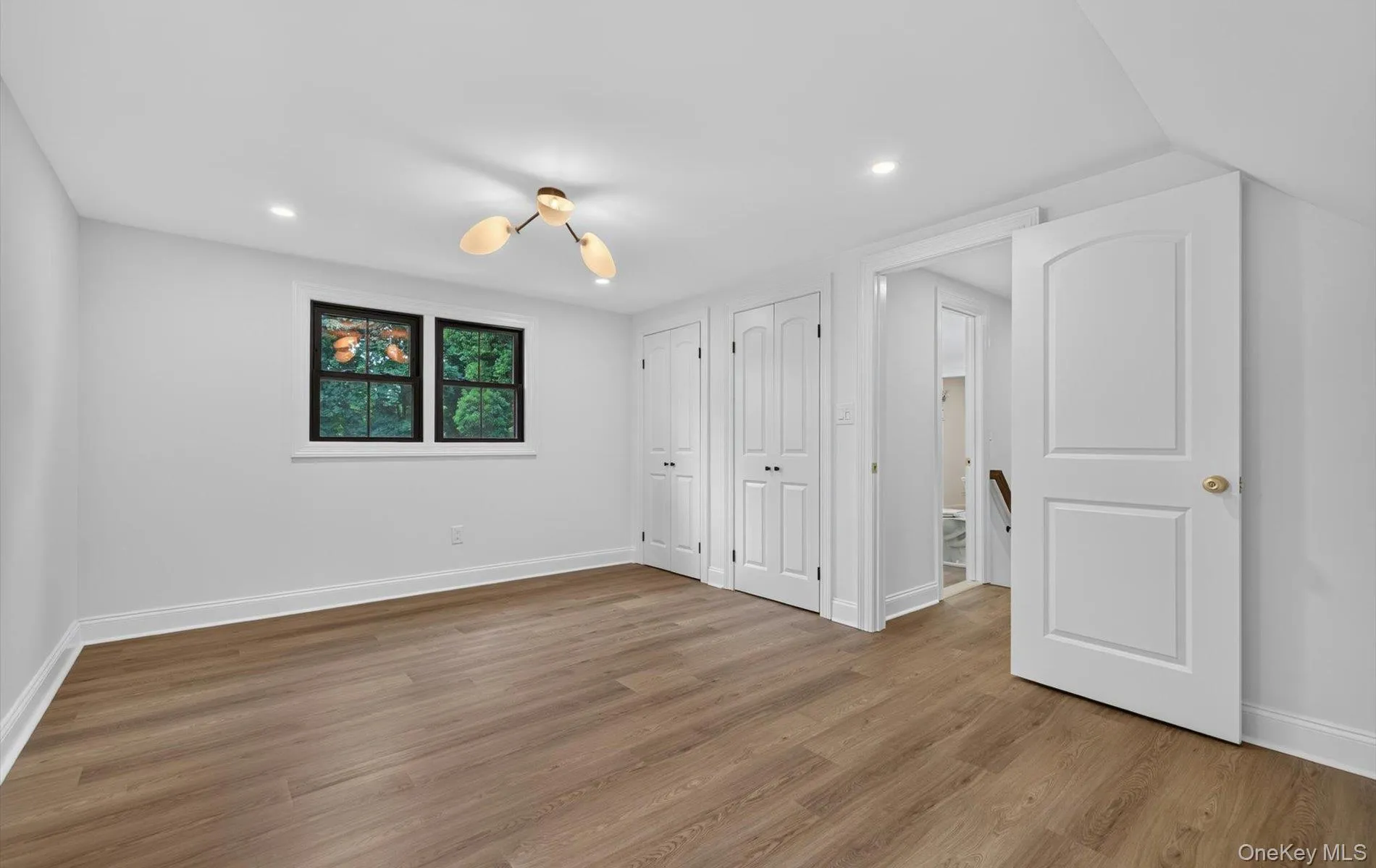 Light wood-finish flooring with white baseboards and neutral wall tones Light wood-finish flooring with white baseboards and neutral wall tones