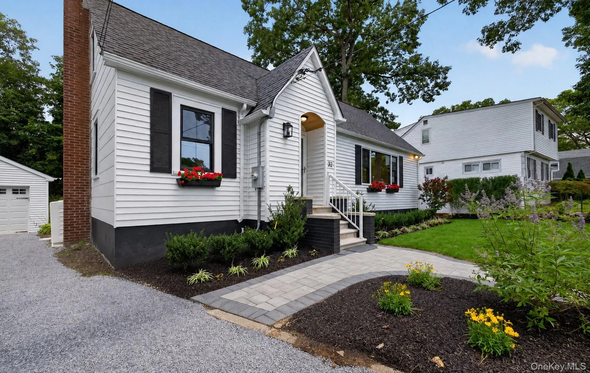 White siding residence featuring a dark shingle roof and black foundation White siding residence featuring a dark shingle roof and black foundation