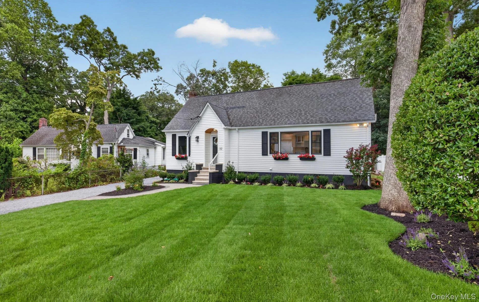 White siding residence featuring black shutters, a dark shingle roof, and a gravel driveway White siding residence featuring black shutters, a dark shingle roof, and a gravel driveway