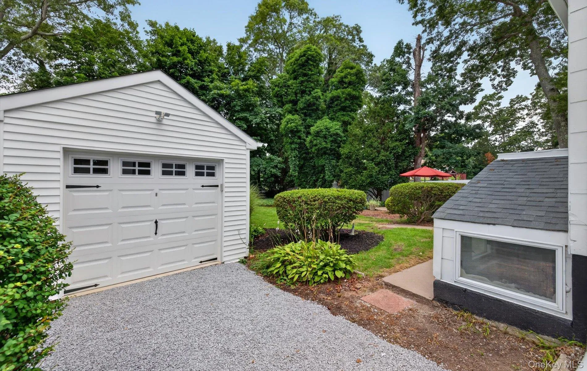 Detached garage featuring a white paneled door with window inserts and decorative hardware Detached garage featuring a white paneled door with window inserts and decorative hardware