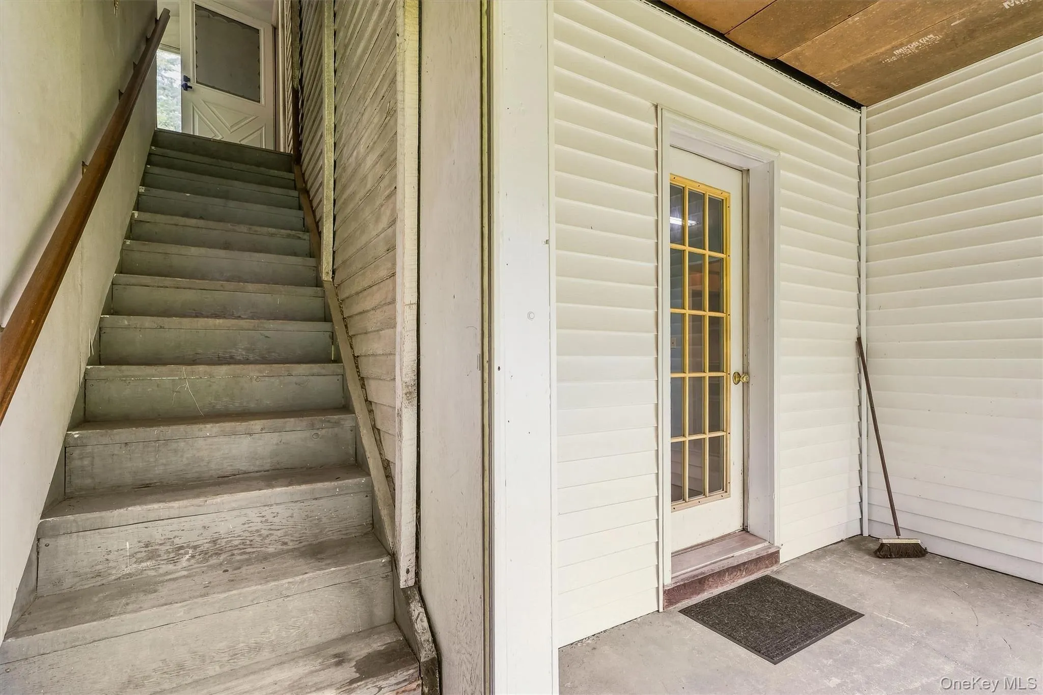 Stairs up to 2nd level & side door to the house entering the laundry room Stairs up to 2nd level & side door to the house entering the laundry room