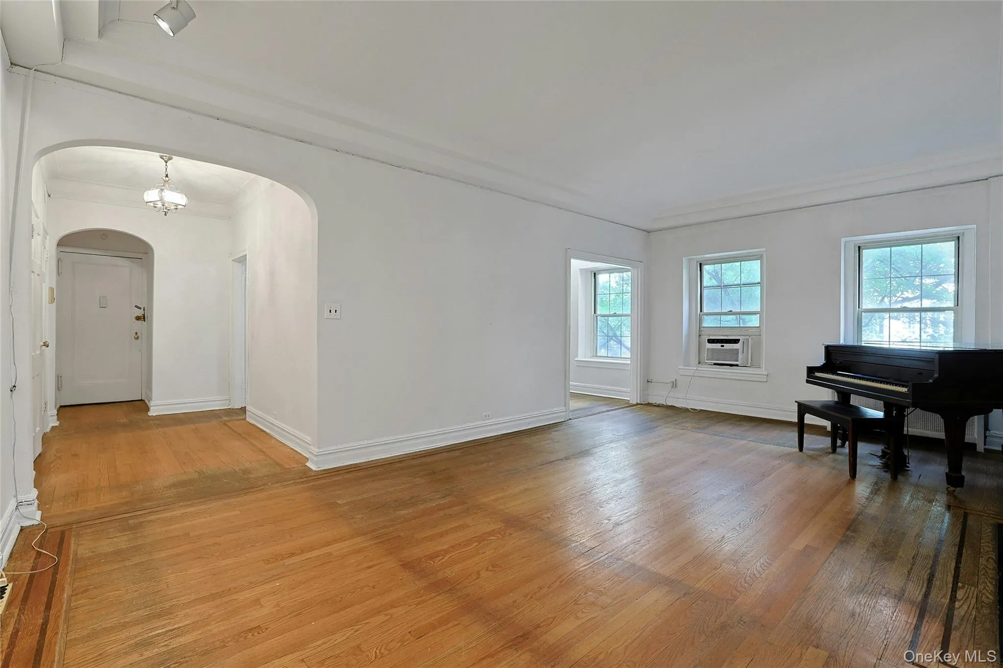 Spacious living room with hardwood floors, multiple exposures, and an open connection to the dining room. Spacious living room with hardwood floors, multiple exposures, and an open connection to the dining room.