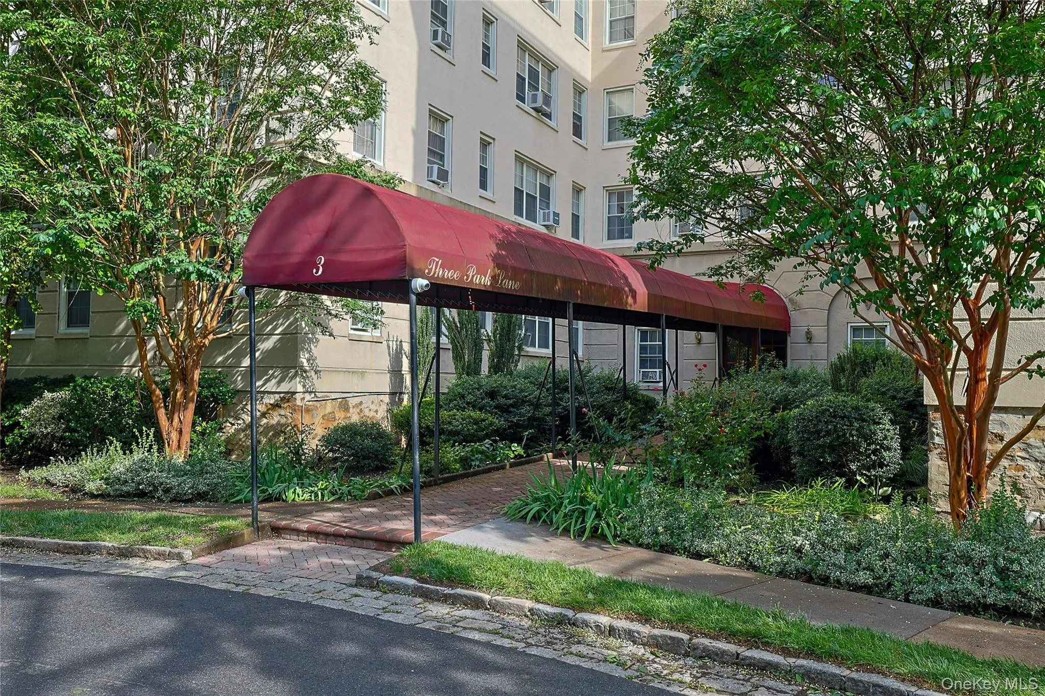 Welcoming covered entrance surrounded by mature landscaping. Welcoming covered entrance surrounded by mature landscaping.