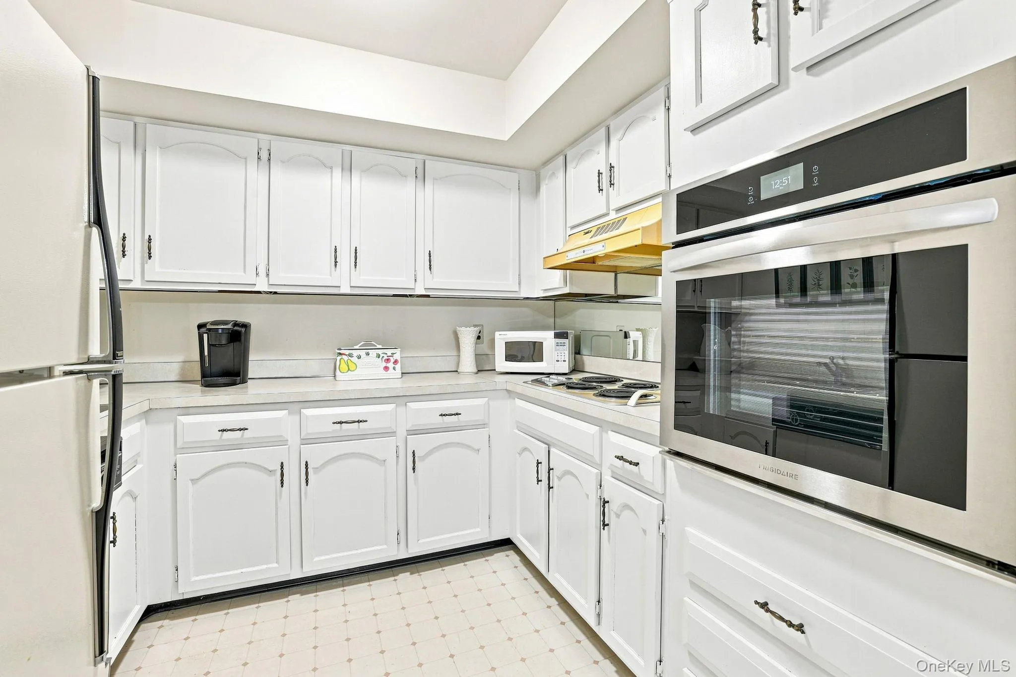 Kitchen with built-in stainless steel oven, electric cooktop, refrigerator and dishwasher Kitchen with built-in stainless steel oven, electric cooktop, refrigerator and dishwasher