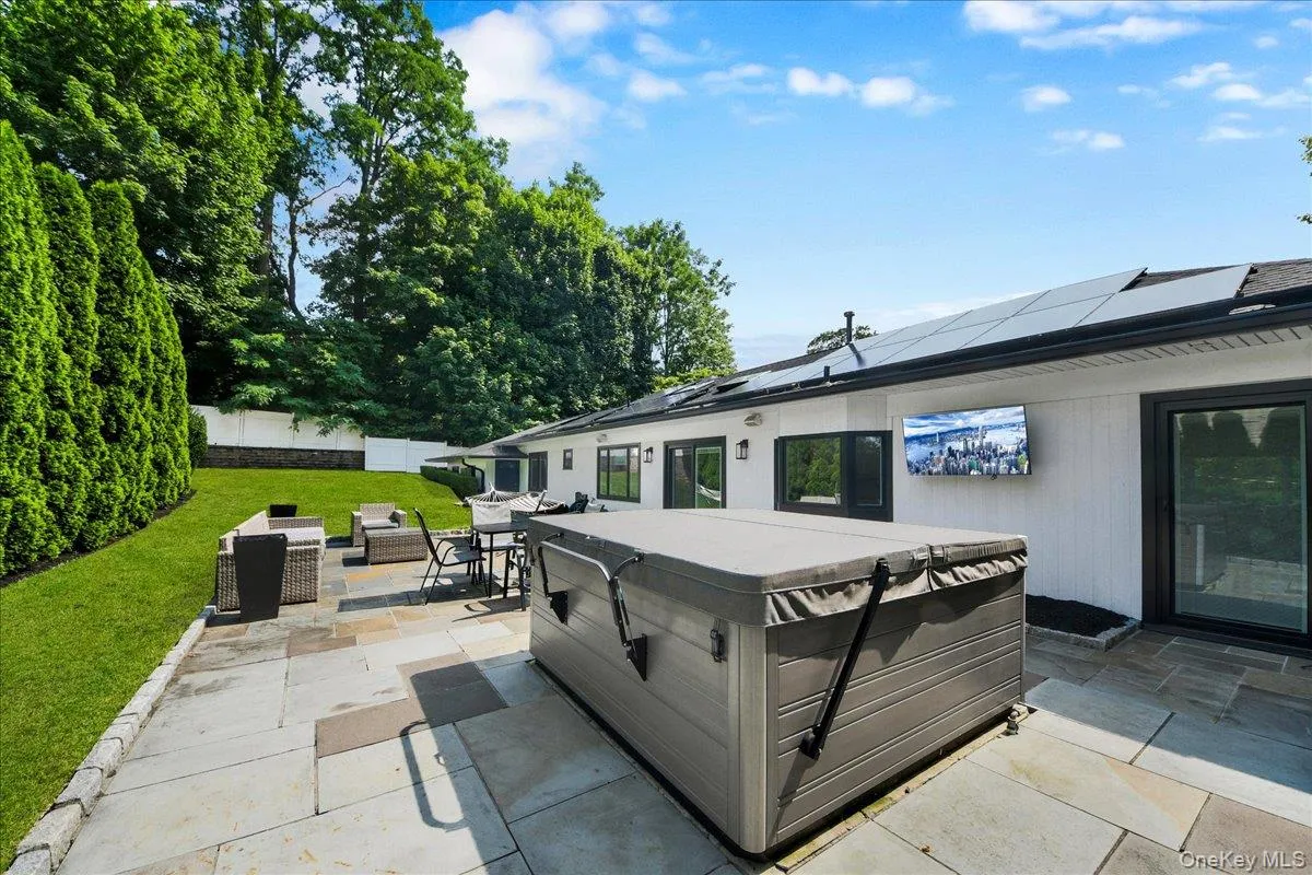 Backyard with stone patio and tv - completely fenced in & lined with privacy trees Backyard with stone patio and tv - completely fenced in & lined with privacy trees