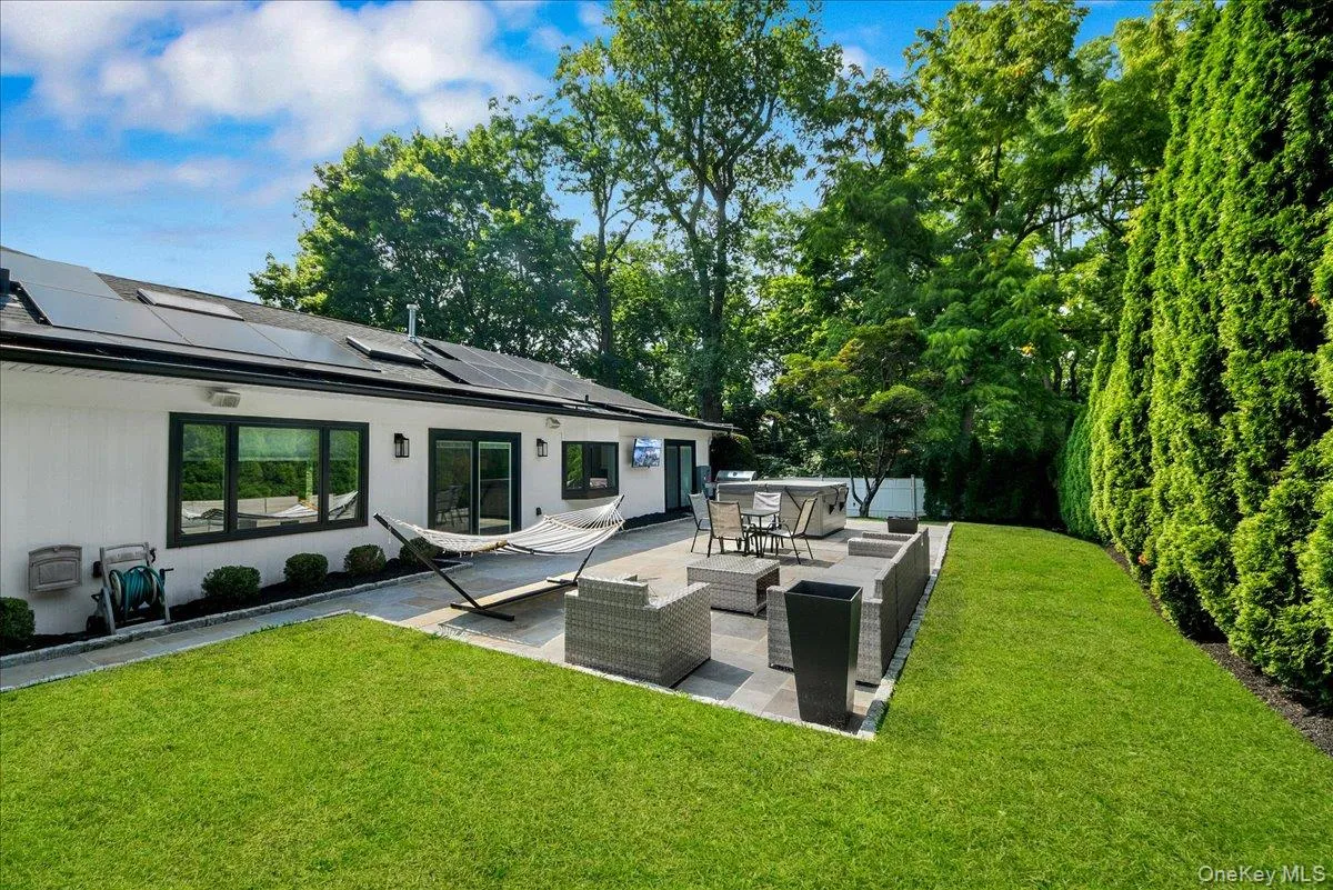 Backyard with stone patio and tv - completely fenced in & lined with privacy trees Backyard with stone patio and tv - completely fenced in & lined with privacy trees