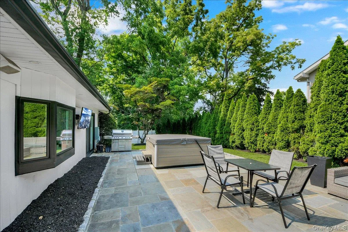 Backyard with stone patio and tv - completely fenced in & lined with privacy trees Backyard with stone patio and tv - completely fenced in & lined with privacy trees