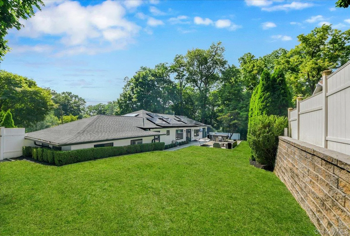 Backyard with stone patio and tv - completely fenced in & lined with privacy trees Backyard with stone patio and tv - completely fenced in & lined with privacy trees