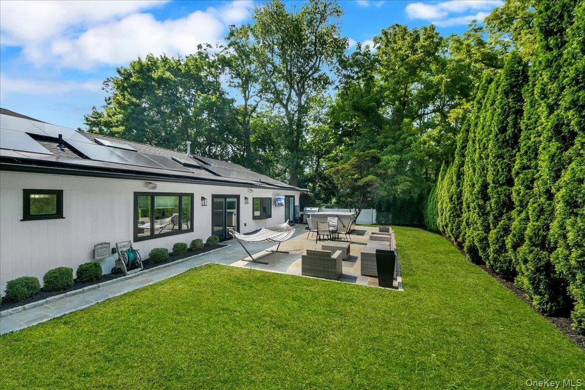 Backyard with stone patio and tv - completely fenced in & lined with privacy trees Backyard with stone patio and tv - completely fenced in & lined with privacy trees