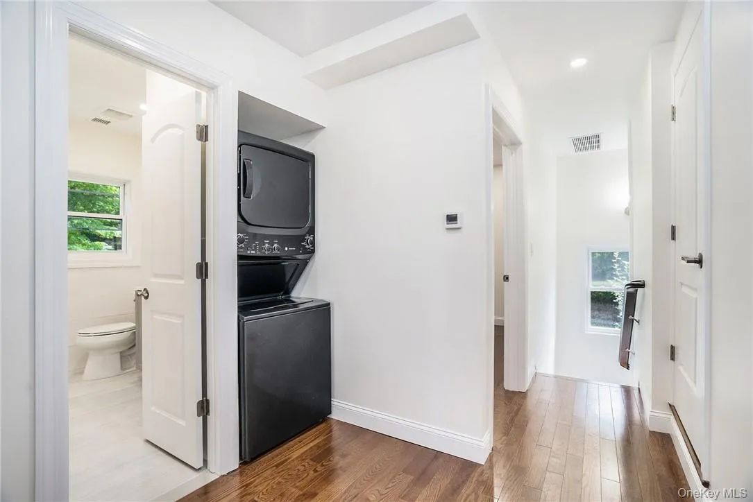 Hall featuring stacked washer and clothes dryer Hall featuring stacked washer and clothes dryer