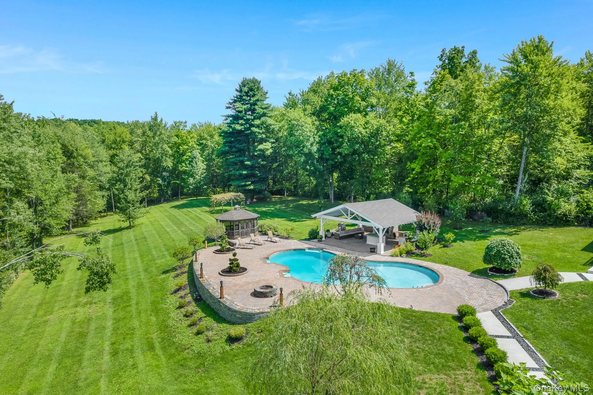 12-foot-deep Gunite in-ground pool, surrounded by a stone patio redone in 2026. 12-foot-deep Gunite in-ground pool, surrounded by a stone patio redone in 2026.
