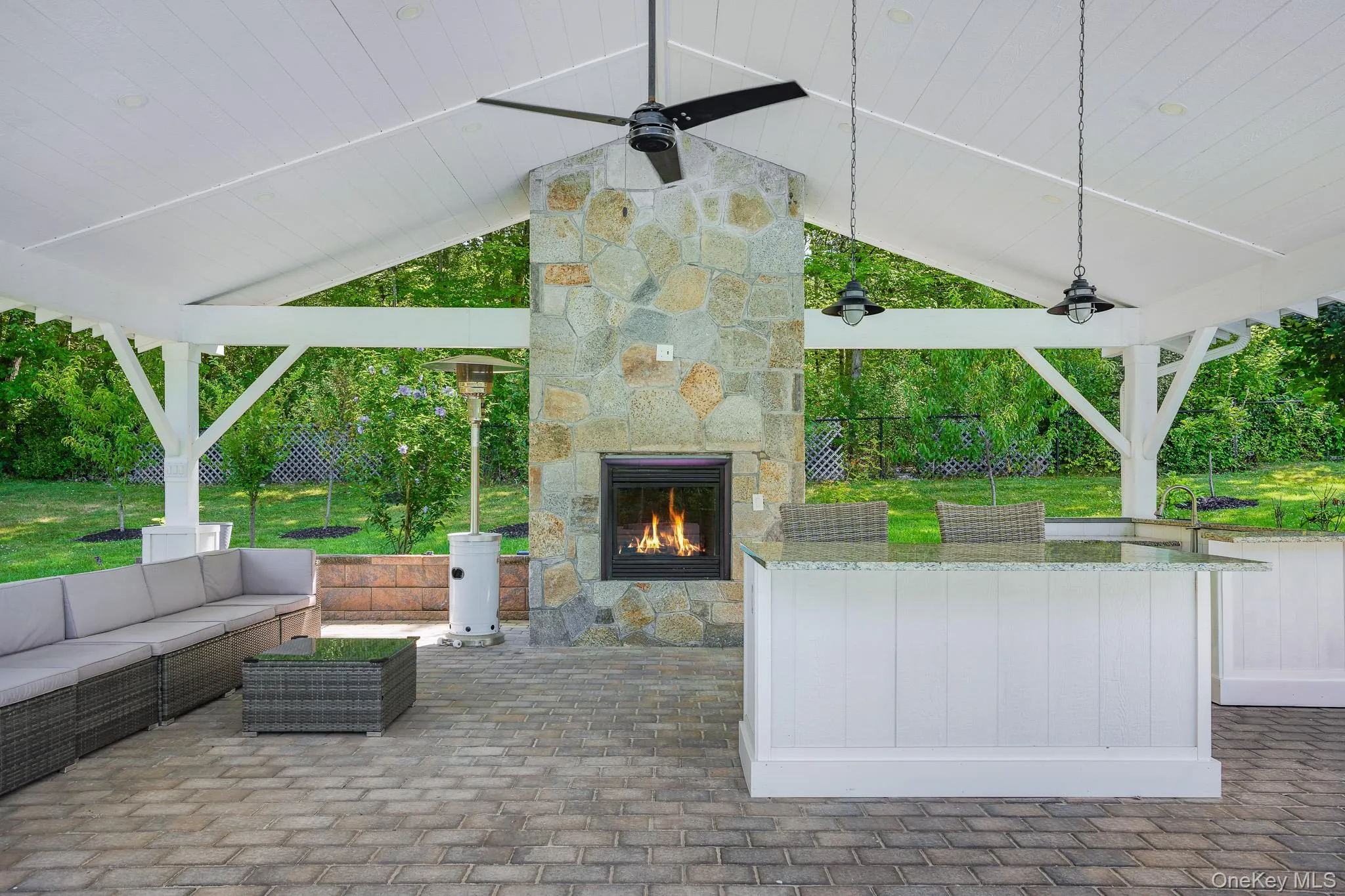 Covered pavilion complete with a sitting area, center island, sink, and electric fireplace. Covered pavilion complete with a sitting area, center island, sink, and electric fireplace.