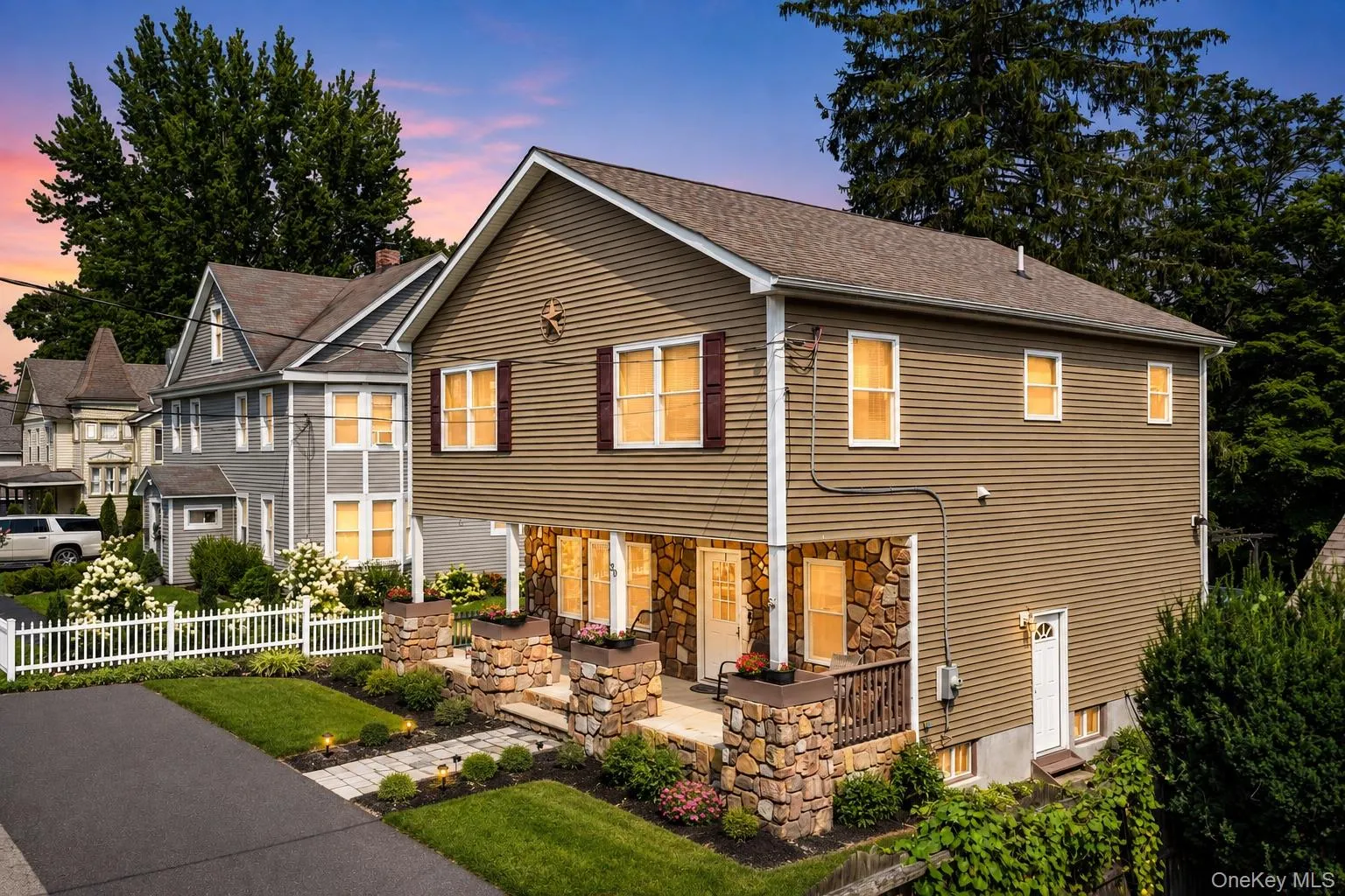 Two-story residence featuring stone siding in twilight Two-story residence featuring stone siding in twilight