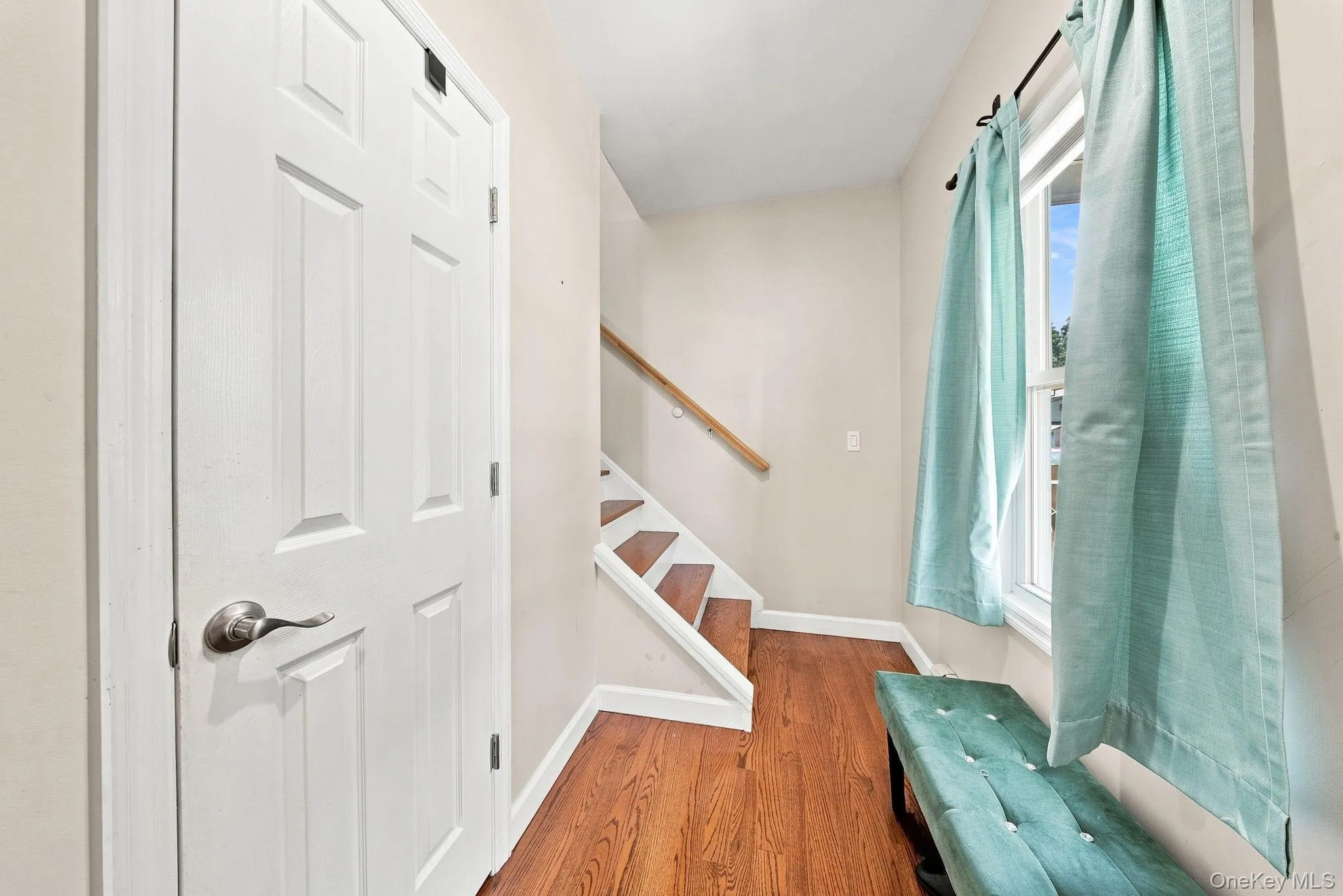 Front entrance leading to stairs featuring hardwood floors. Front entrance leading to stairs featuring hardwood floors.