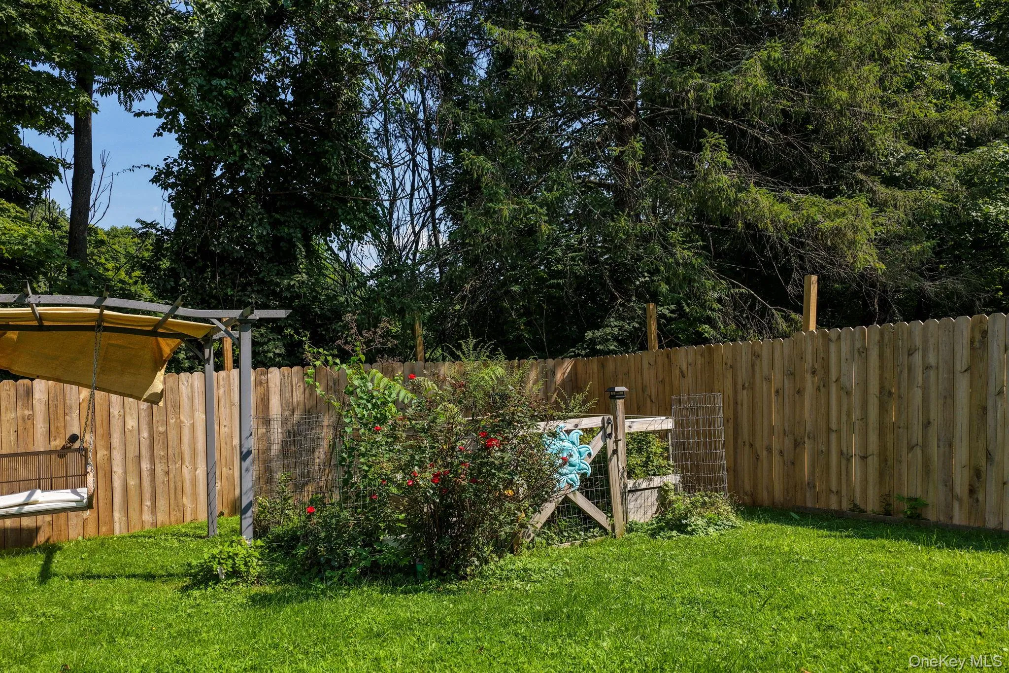 Spacious backyard with lush, manicured lawn and mature tree canopy providing natural shade Spacious backyard with lush, manicured lawn and mature tree canopy providing natural shade