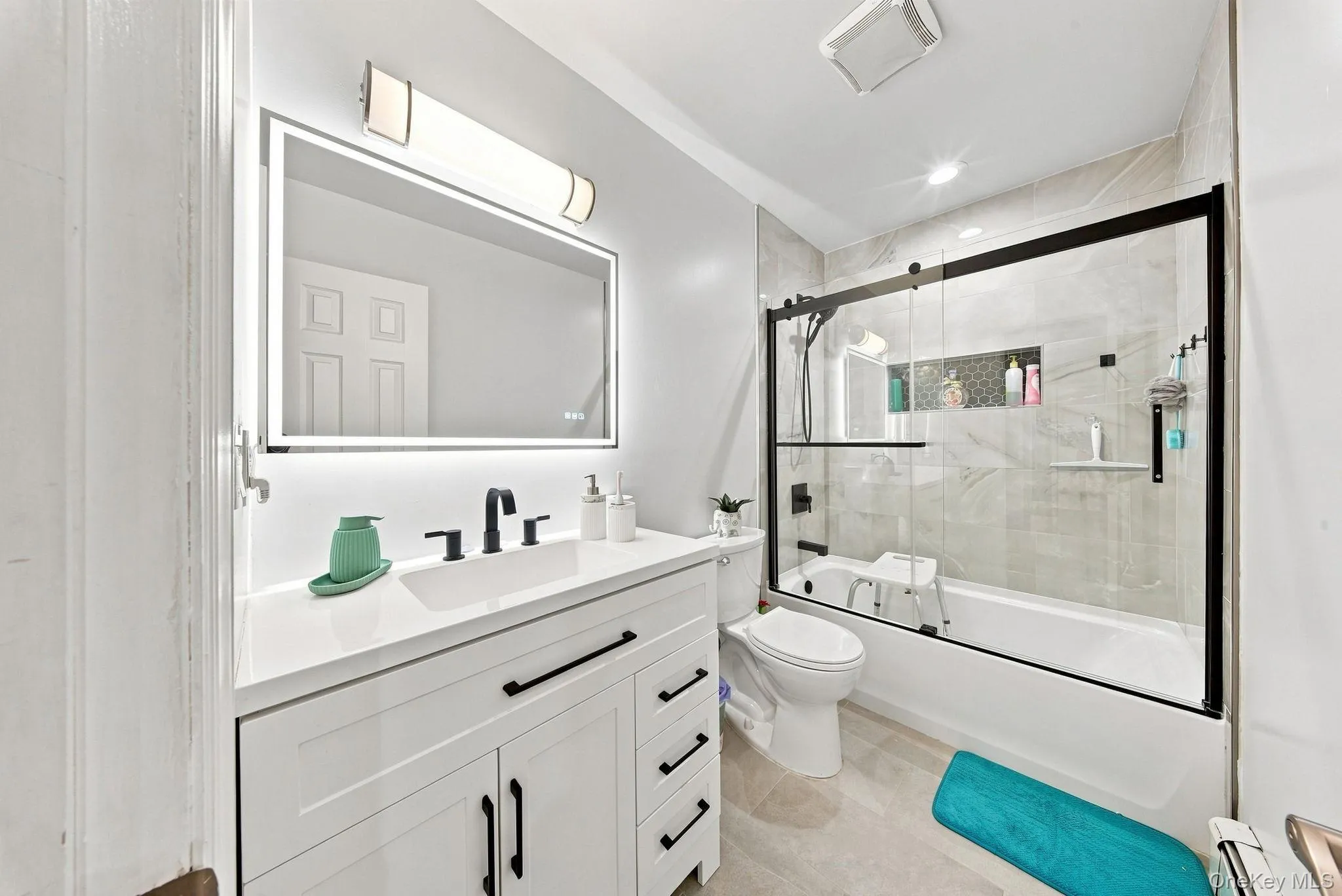 Modern primary bathroom featuring a floating vanity with rectangular vessel sink, quartz countertop, and matte black hardware Modern primary bathroom featuring a floating vanity with rectangular vessel sink, quartz countertop, and matte black hardware