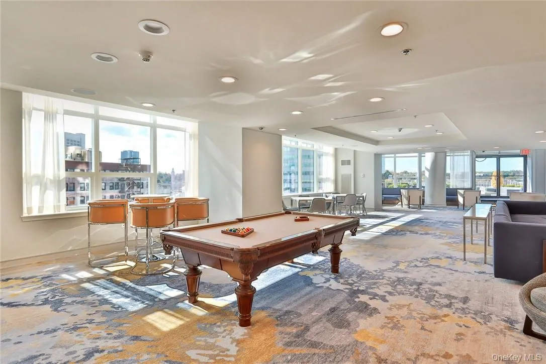 Playroom with light carpet, a tray ceiling, and pool table Playroom with light carpet, a tray ceiling, and pool table