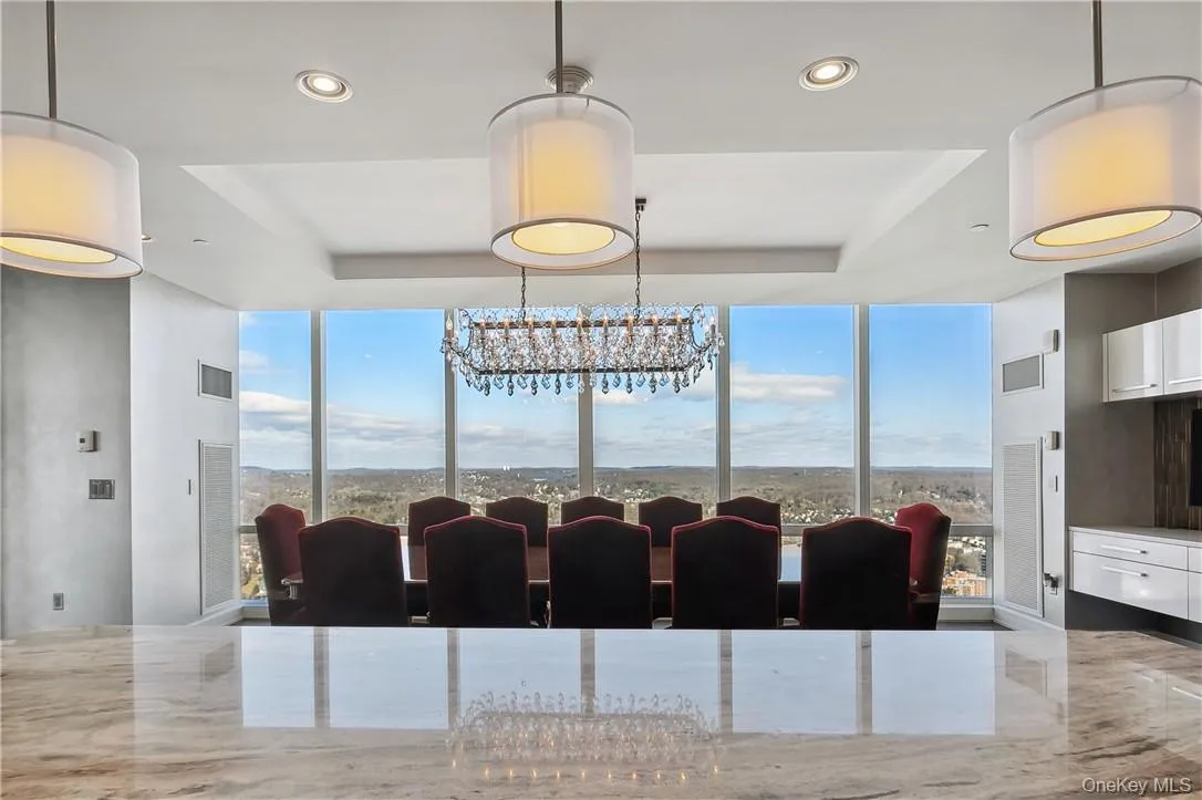 Dining space featuring a raised ceiling, an inviting chandelier, and plenty of natural light Dining space featuring a raised ceiling, an inviting chandelier, and plenty of natural light