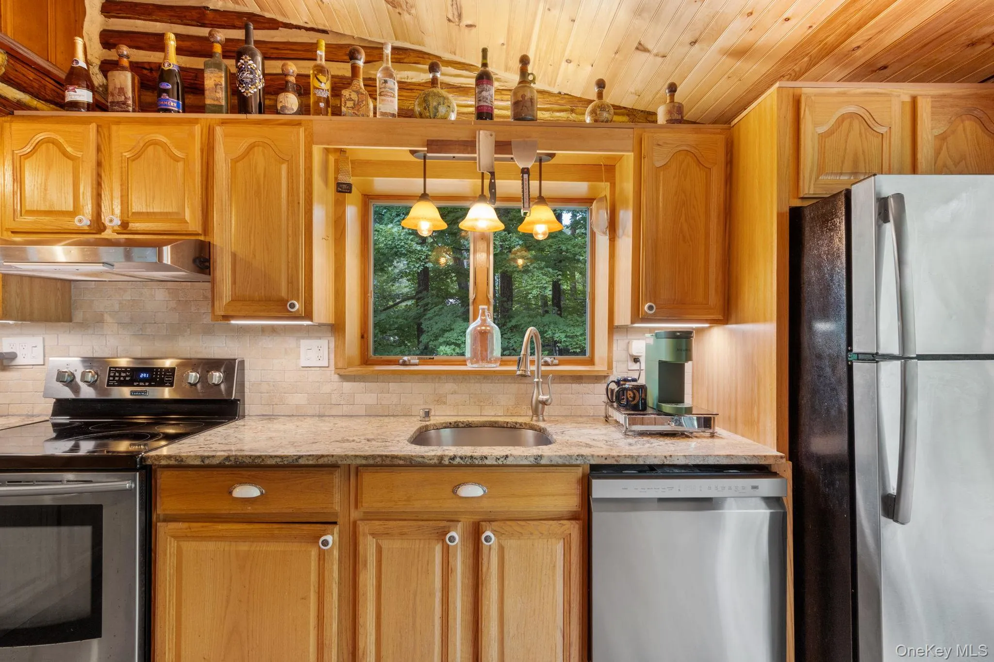 Gorgeous wooded views from the kitchen sink window bring a peaceful, natural backdrop to the space. Gorgeous wooded views from the kitchen sink window bring a peaceful, natural backdrop to the space.
