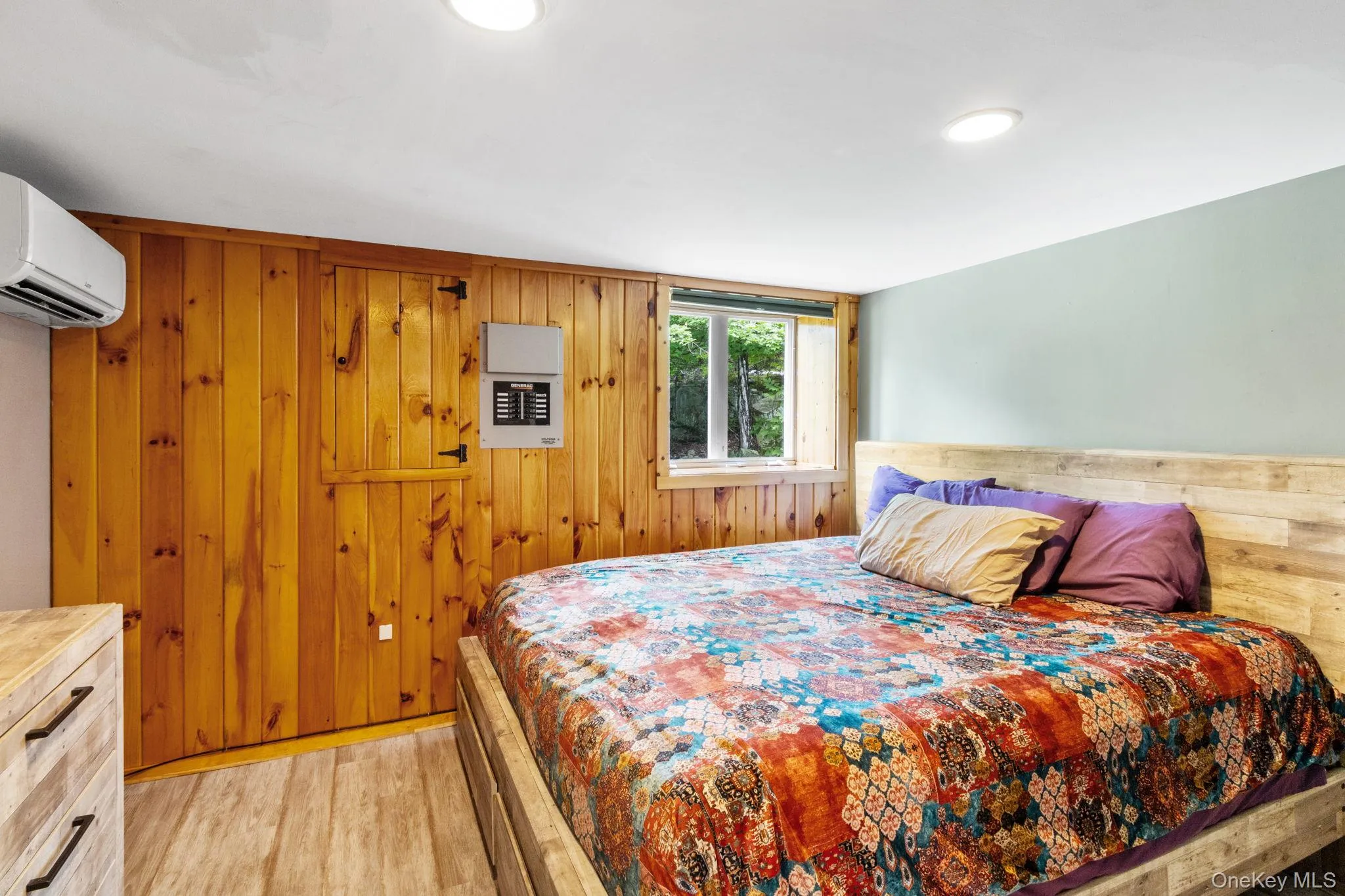 The first of two cozy bedrooms located on the main level, featuring peaceful forest views. The first of two cozy bedrooms located on the main level, featuring peaceful forest views.