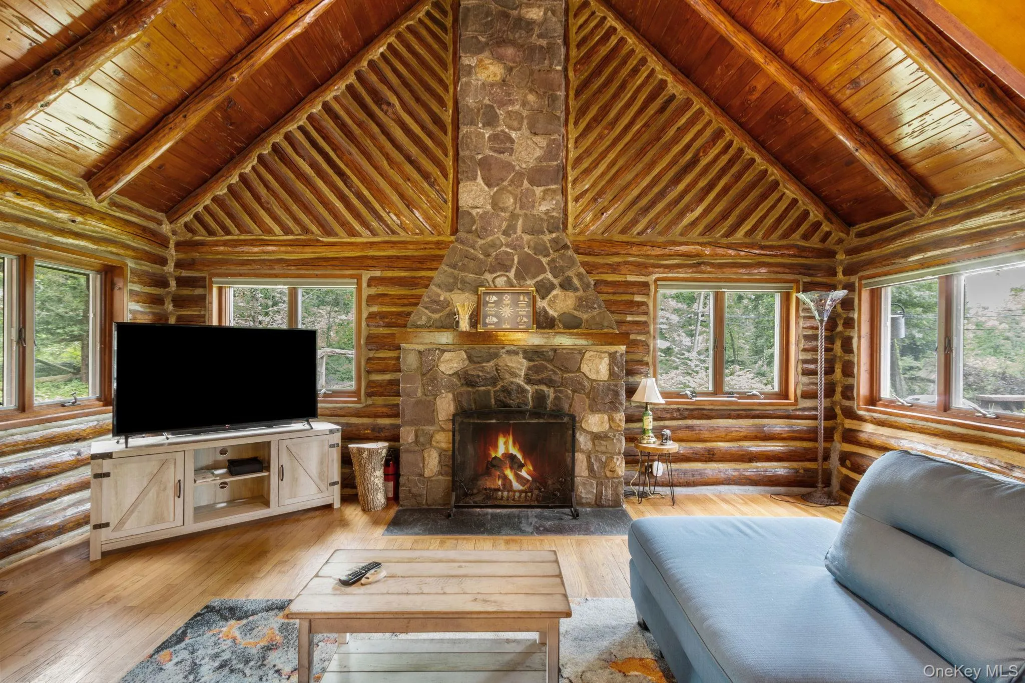 Vaulted great room with a gas fireplace, wrapped in windows that overlook the yard and peaceful woods beyond. Vaulted great room with a gas fireplace, wrapped in windows that overlook the yard and peaceful woods beyond.