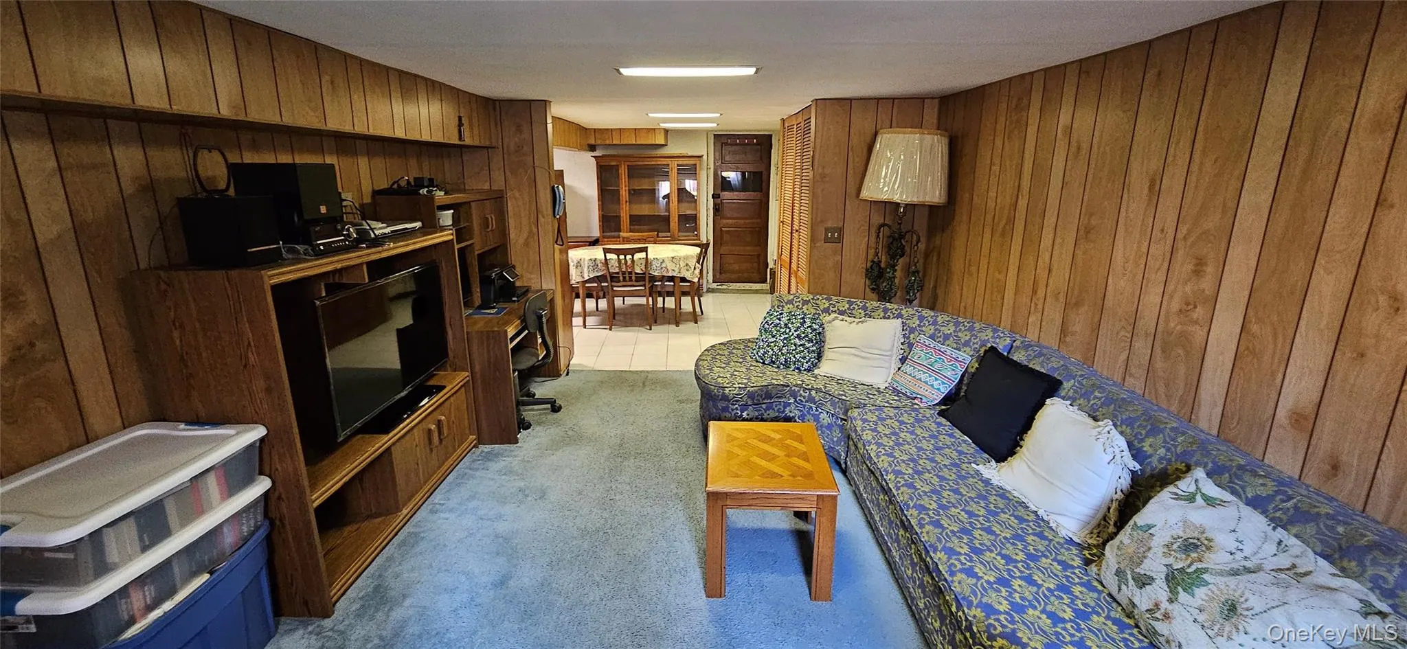 Living area featuring wooden walls and light carpet Living area featuring wooden walls and light carpet