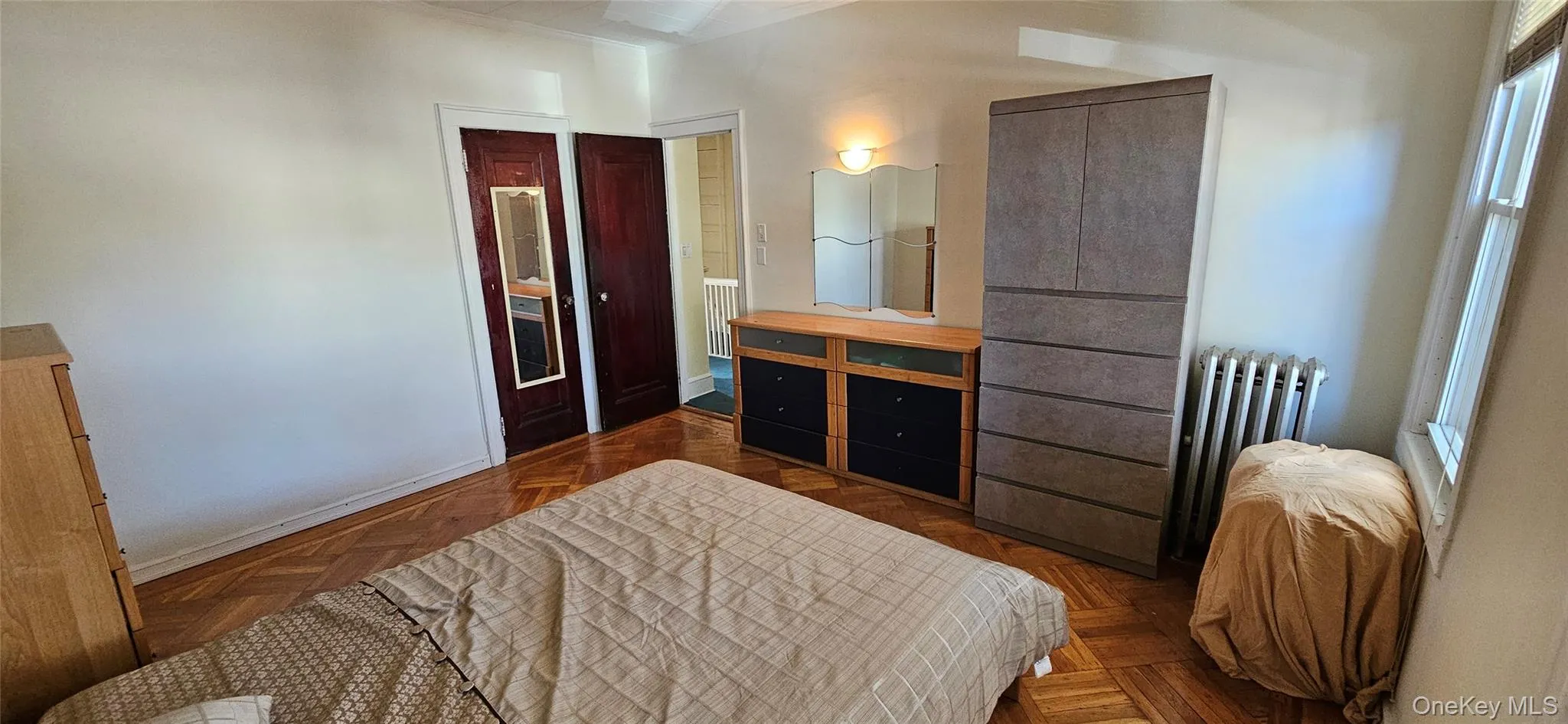 Bedroom with radiator, ornamental molding, and a closet Bedroom with radiator, ornamental molding, and a closet