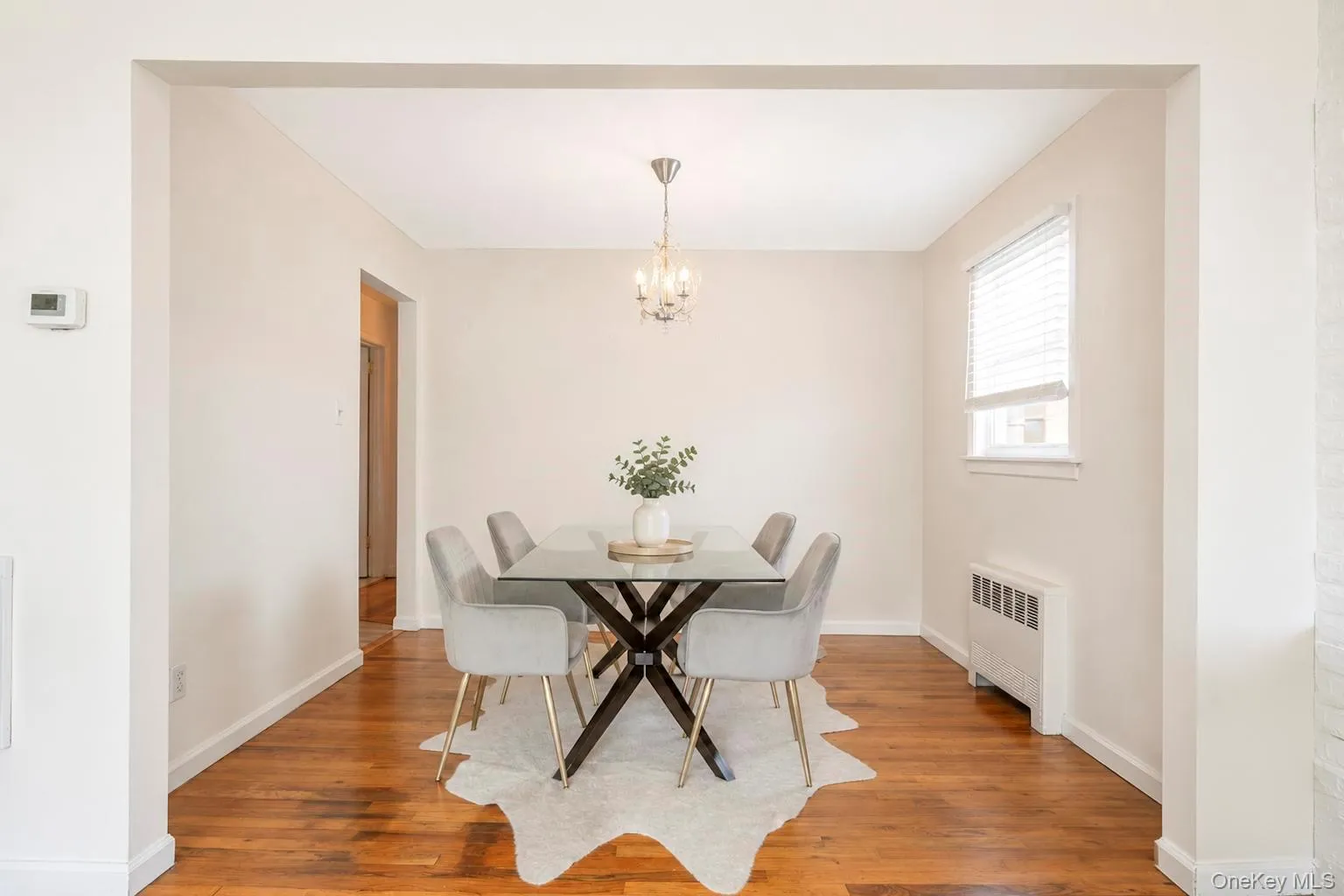 Dining area featuring wood-finish flooring, light-colored walls, and a window with blinds Dining area featuring wood-finish flooring, light-colored walls, and a window with blinds