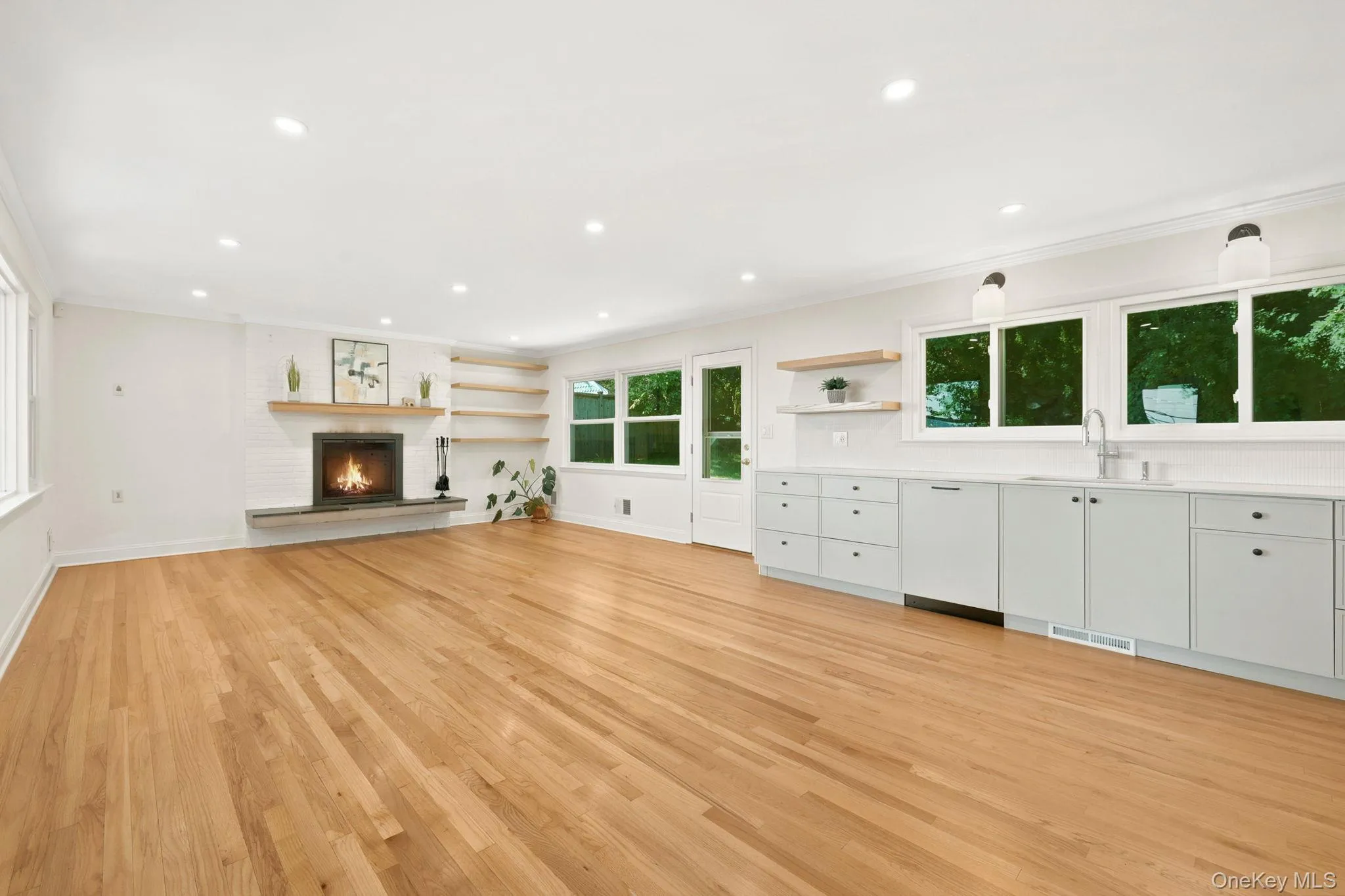 Open concept living room, kitchen and dining area. There is a door to the rear garden patio. Open concept living room, kitchen and dining area. There is a door to the rear garden patio.