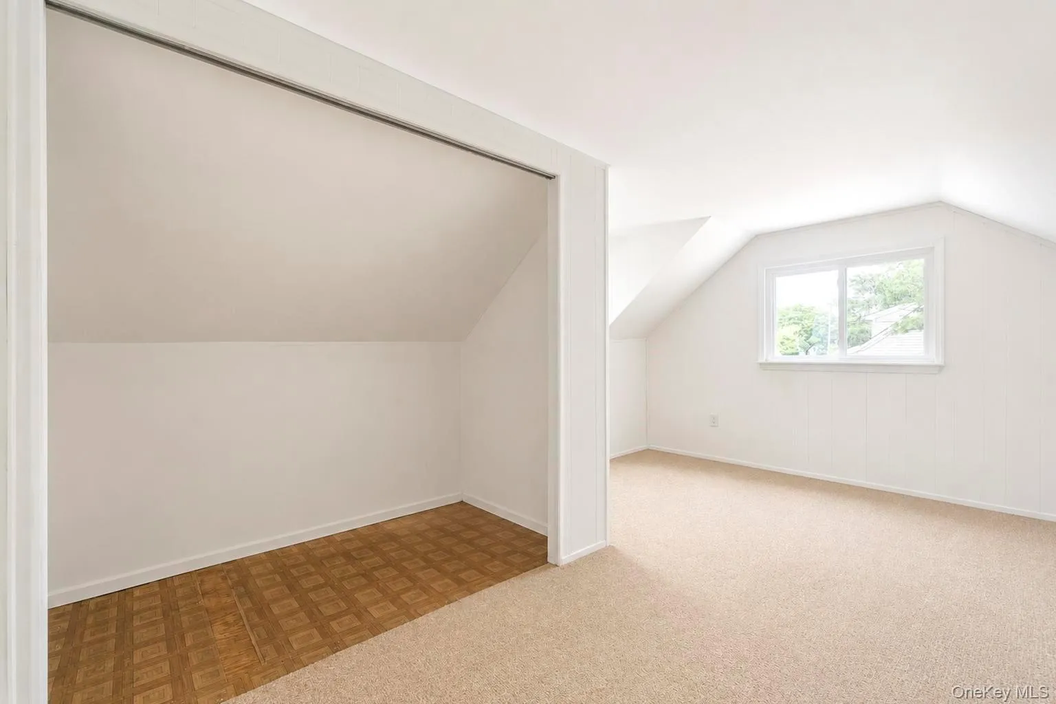 Bedroom # 3 Sloped ceiling room featuring a window with exterior visibility, light-toned carpeting, and a built-in storage area with patterned flooring Bedroom # 3 Sloped ceiling room featuring a window with exterior visibility, light-toned carpeting, and a built-in storage area with patterned flooring