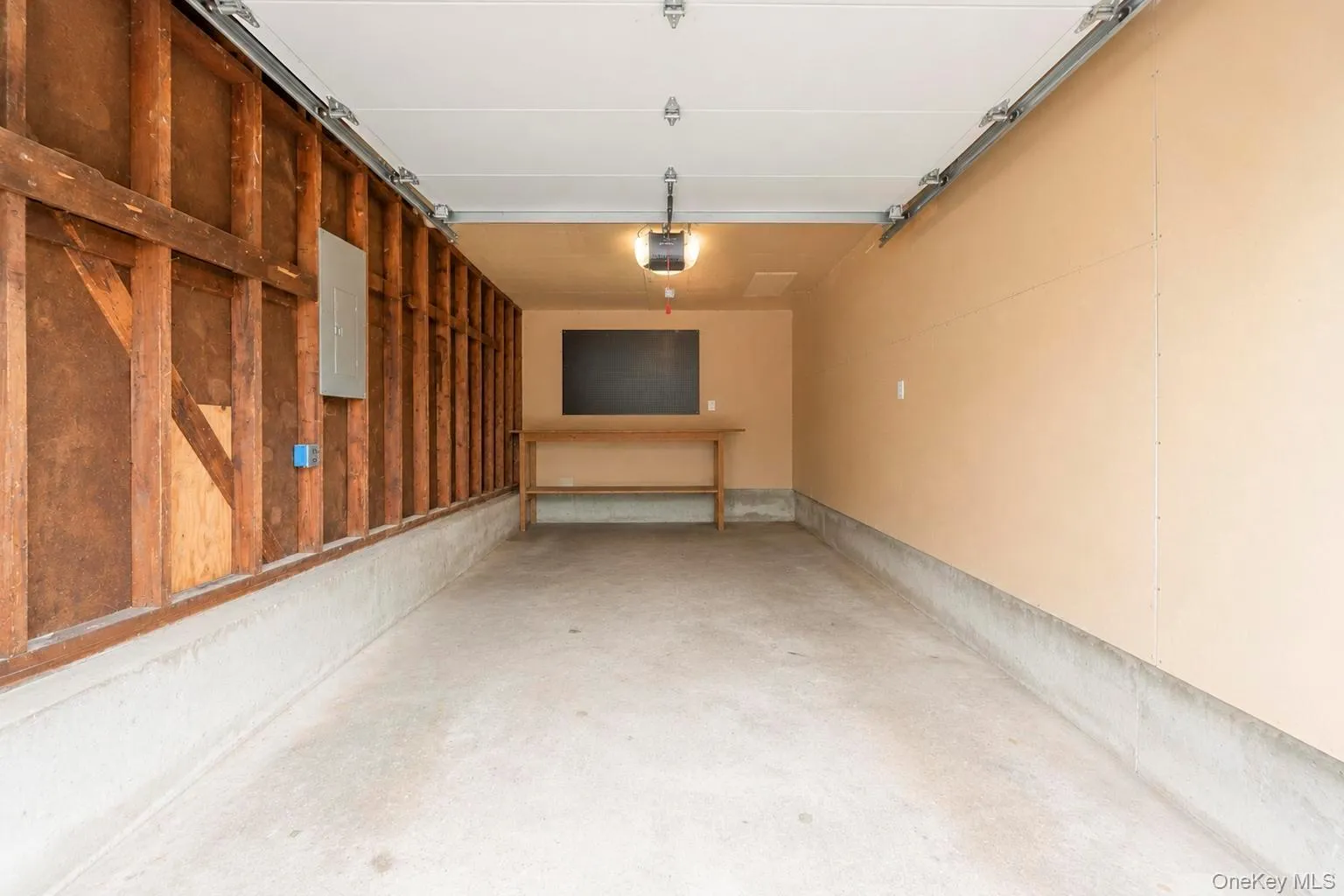 Spacious garage with concrete flooring, exposed wood framing, and painted walls 200 amp electrical panel Spacious garage with concrete flooring, exposed wood framing, and painted walls 200 amp electrical panel