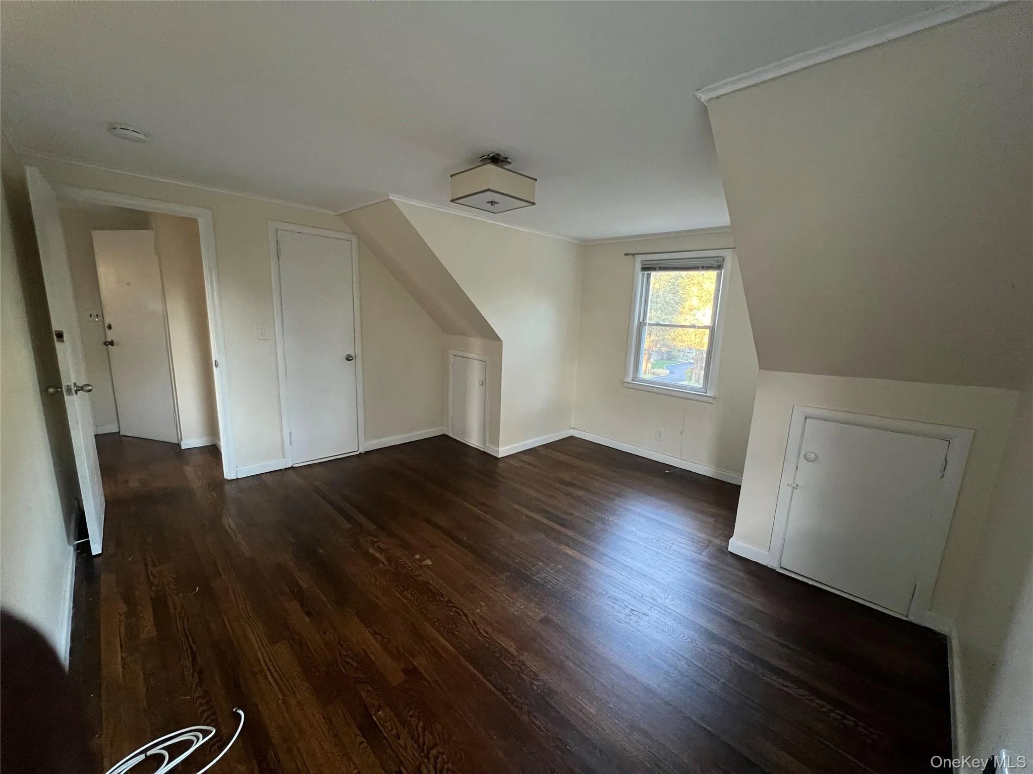 Bonus room featuring dark wood-style flooring and baseboards Bonus room featuring dark wood-style flooring and baseboards