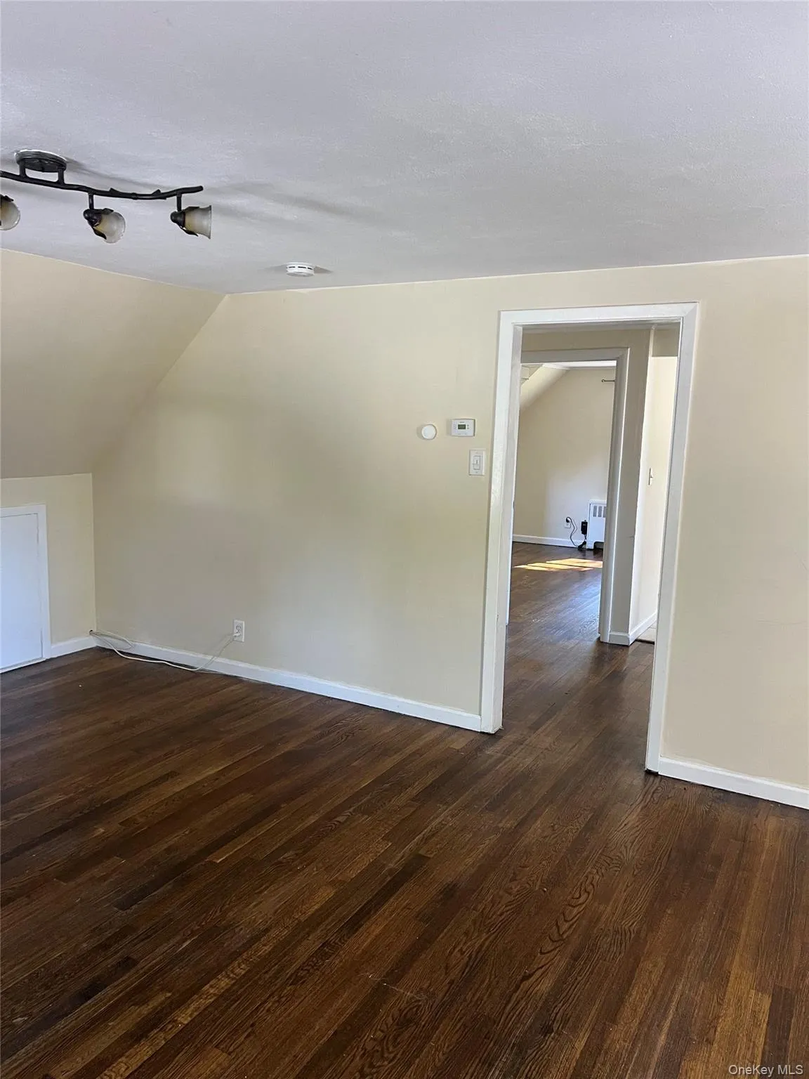 Bonus room with vaulted ceiling and dark wood-style floors Bonus room with vaulted ceiling and dark wood-style floors