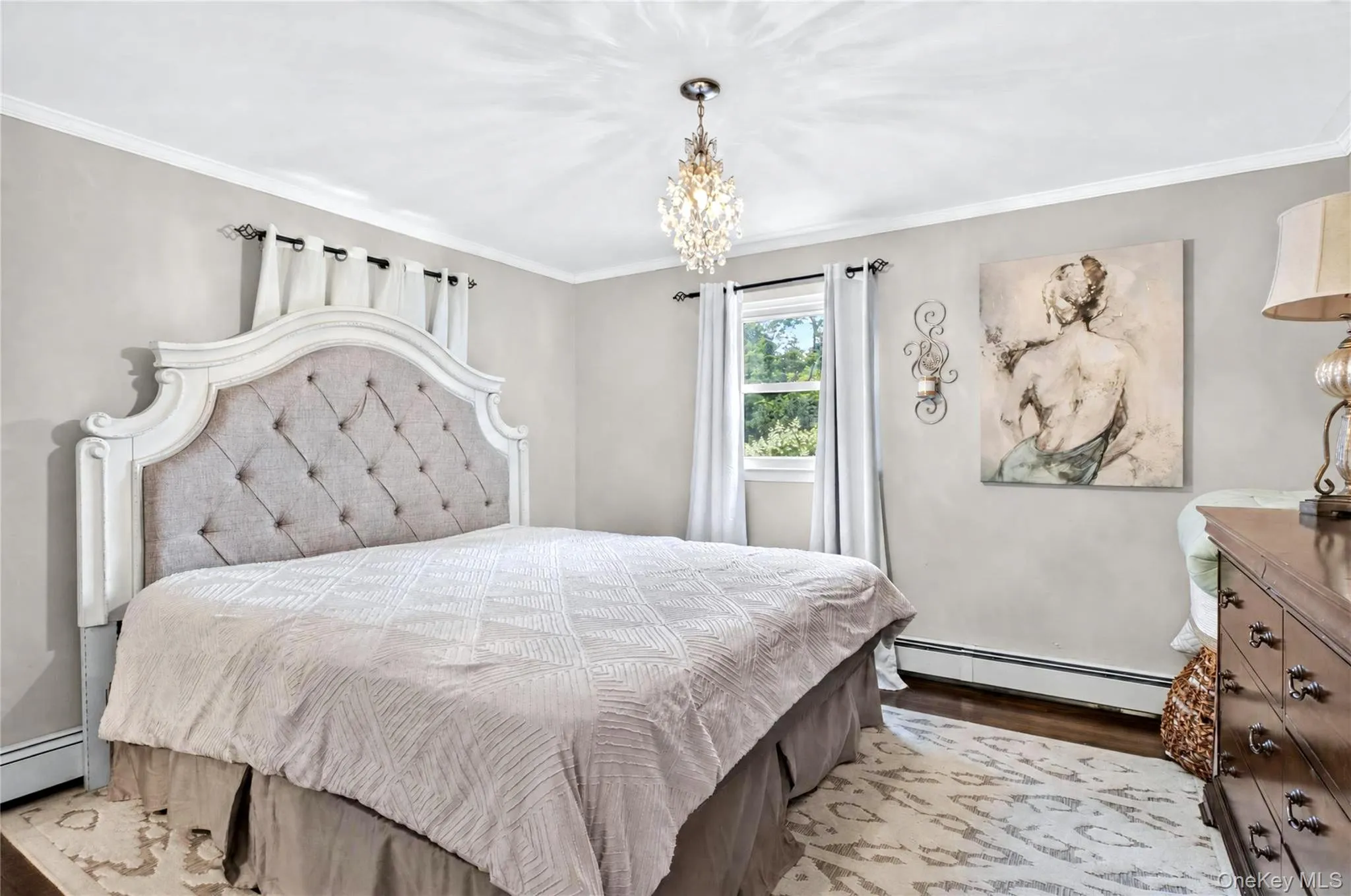 Primary bedroom with hardwood floors and marbled bath. Primary bedroom with hardwood floors and marbled bath.