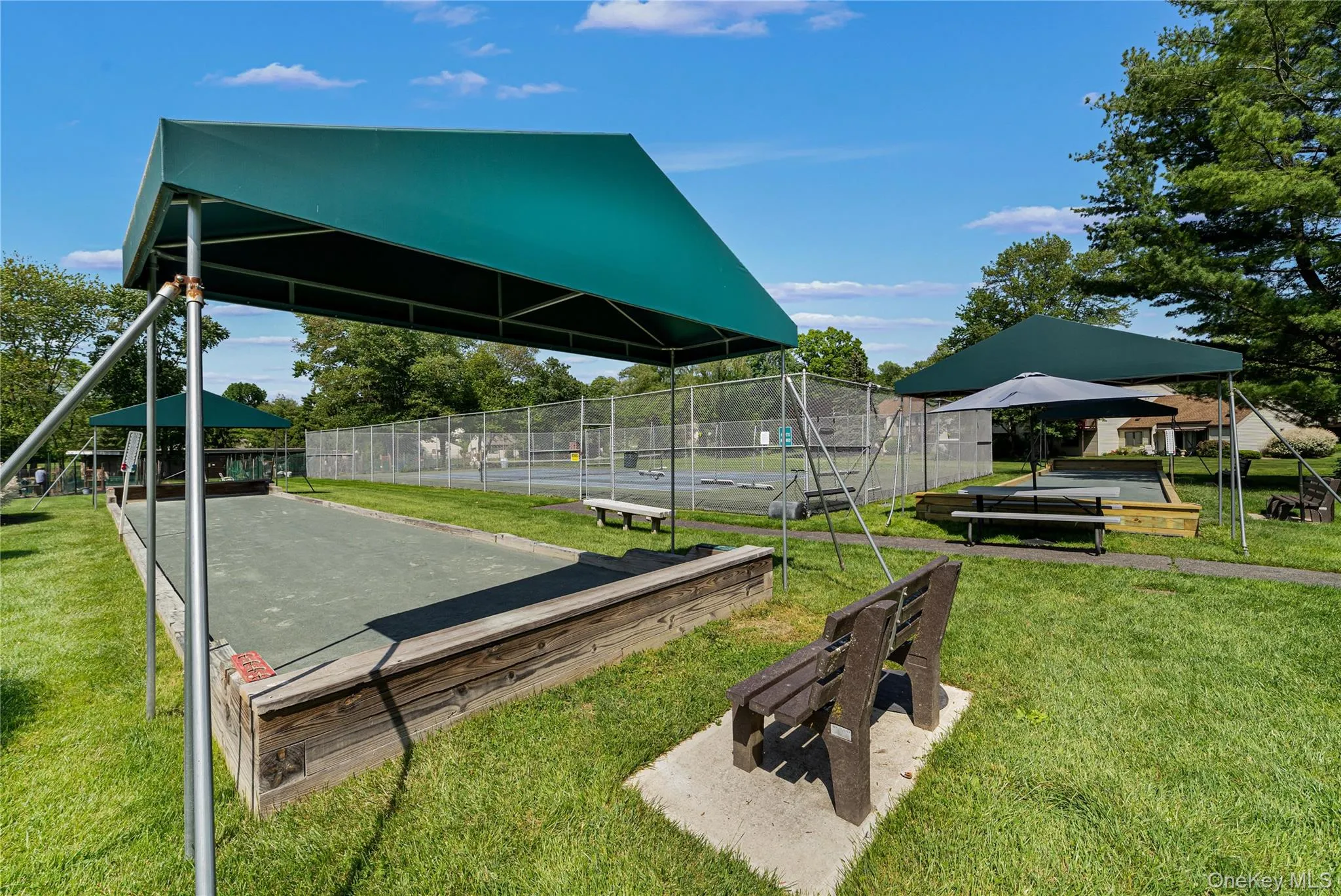 Bocce, Shuffleboard and Tennis with seating areas and green space. Bocce, Shuffleboard and Tennis with seating areas and green space.