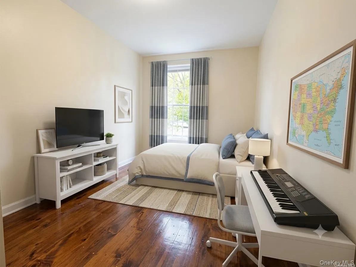 Room featuring wood-finish flooring, neutral wall tones, and a window with natural light Room featuring wood-finish flooring, neutral wall tones, and a window with natural light