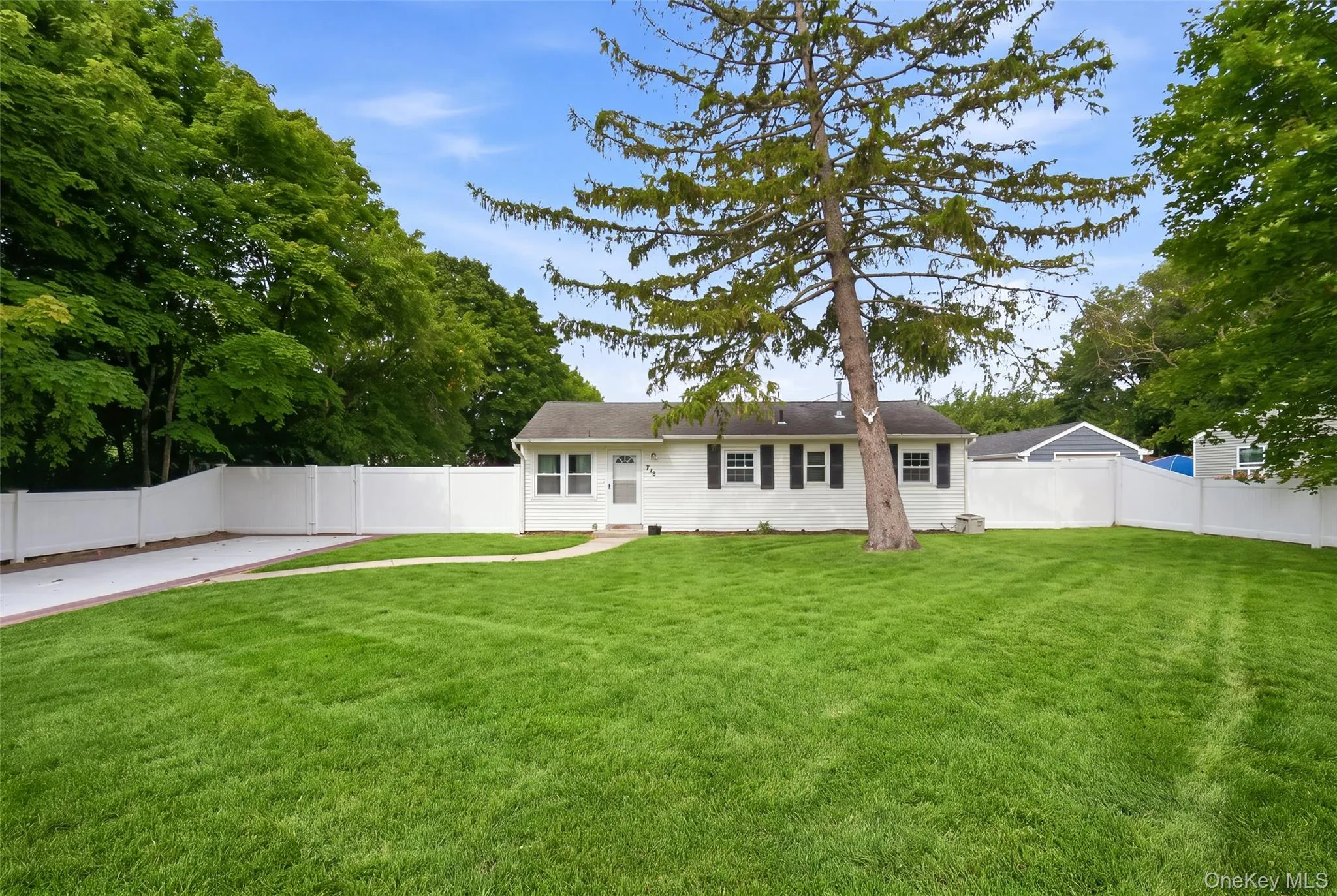 Single-story ranch home with a white exterior and dark window shutters Single-story ranch home with a white exterior and dark window shutters