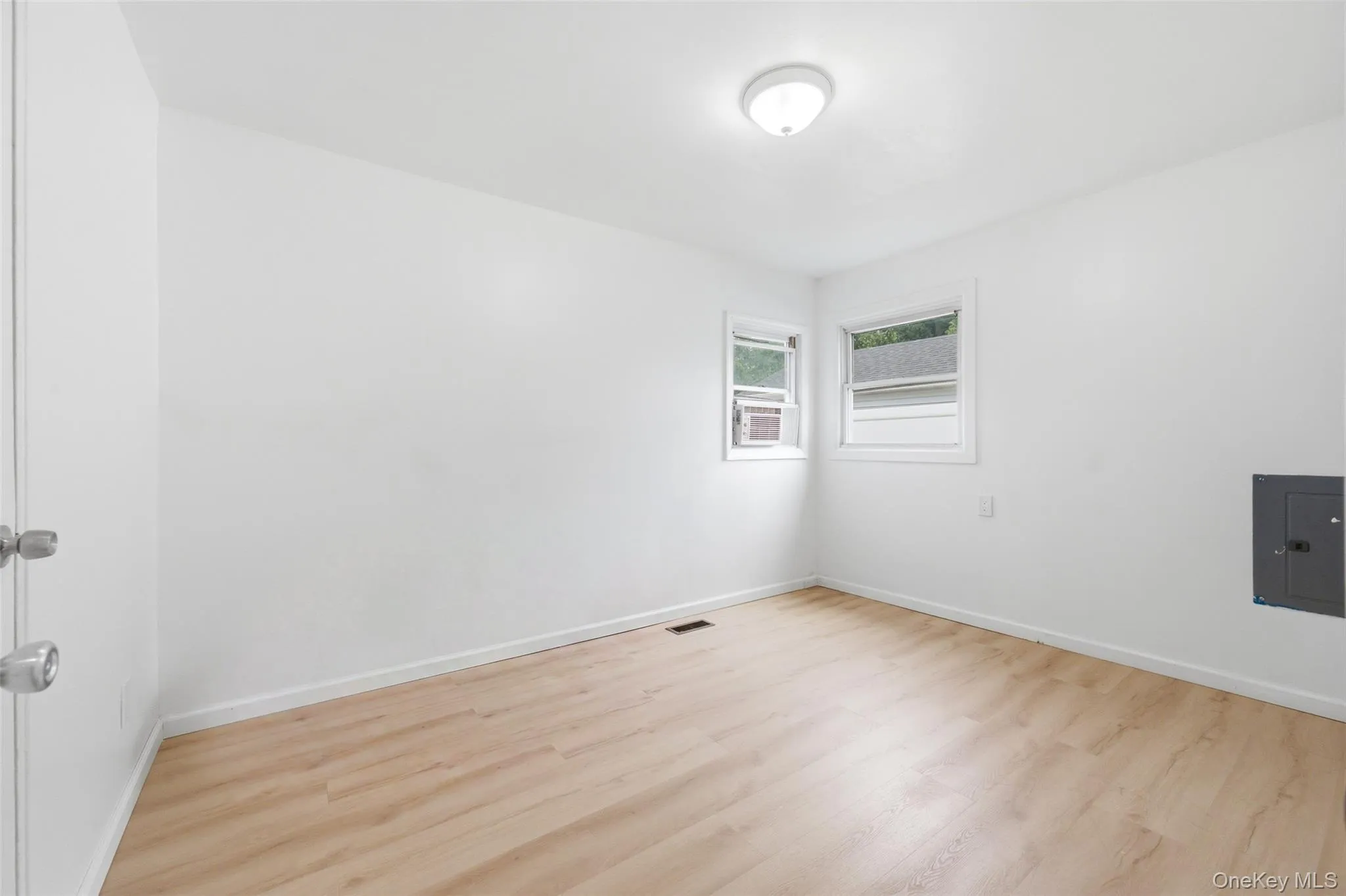 Bright interior space featuring light wood-finish flooring, white walls, and white trim Bright interior space featuring light wood-finish flooring, white walls, and white trim