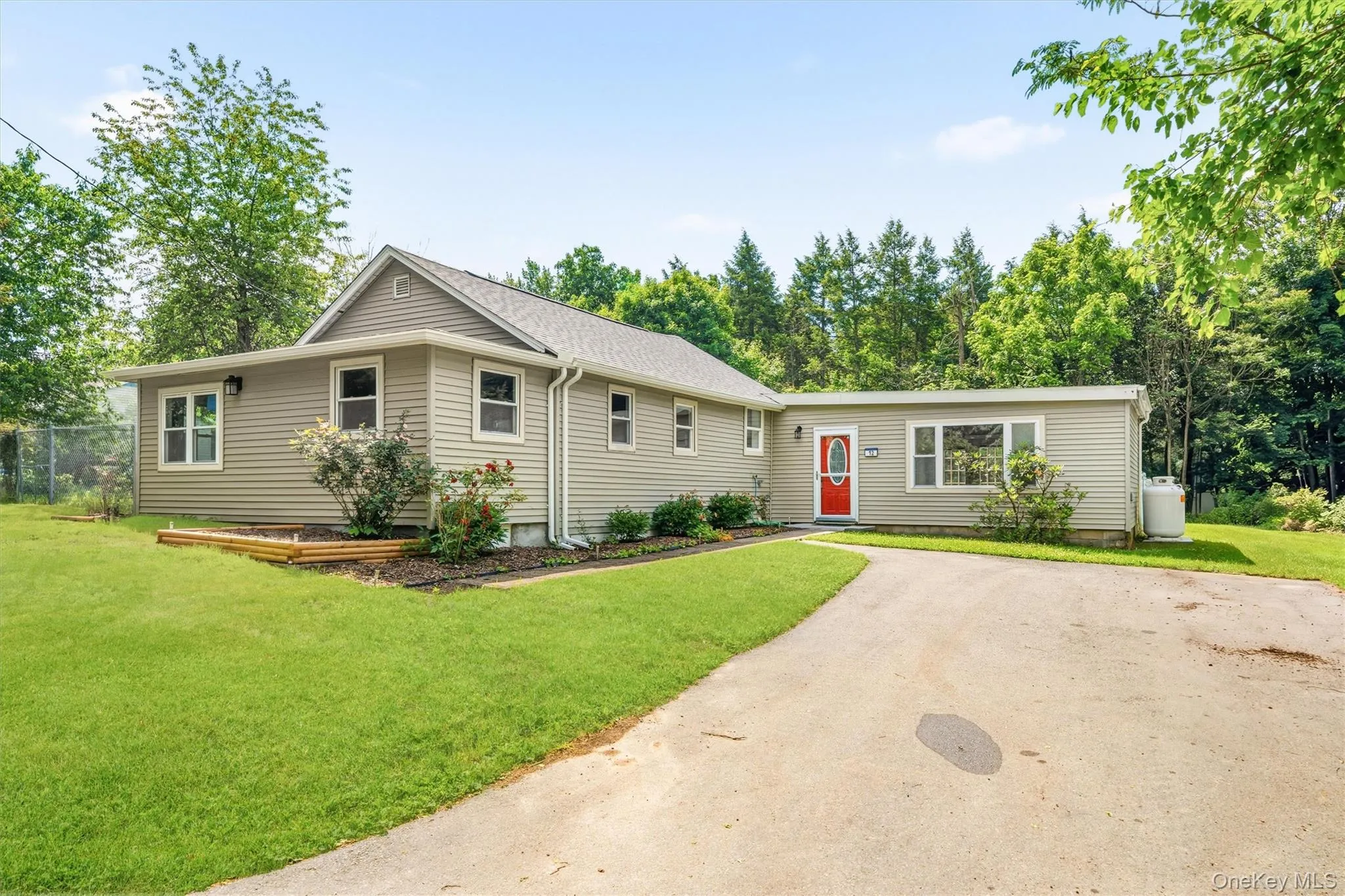Charming ranch-style home featuring tan vinyl siding, multiple gabled rooflines. Charming ranch-style home featuring tan vinyl siding, multiple gabled rooflines.