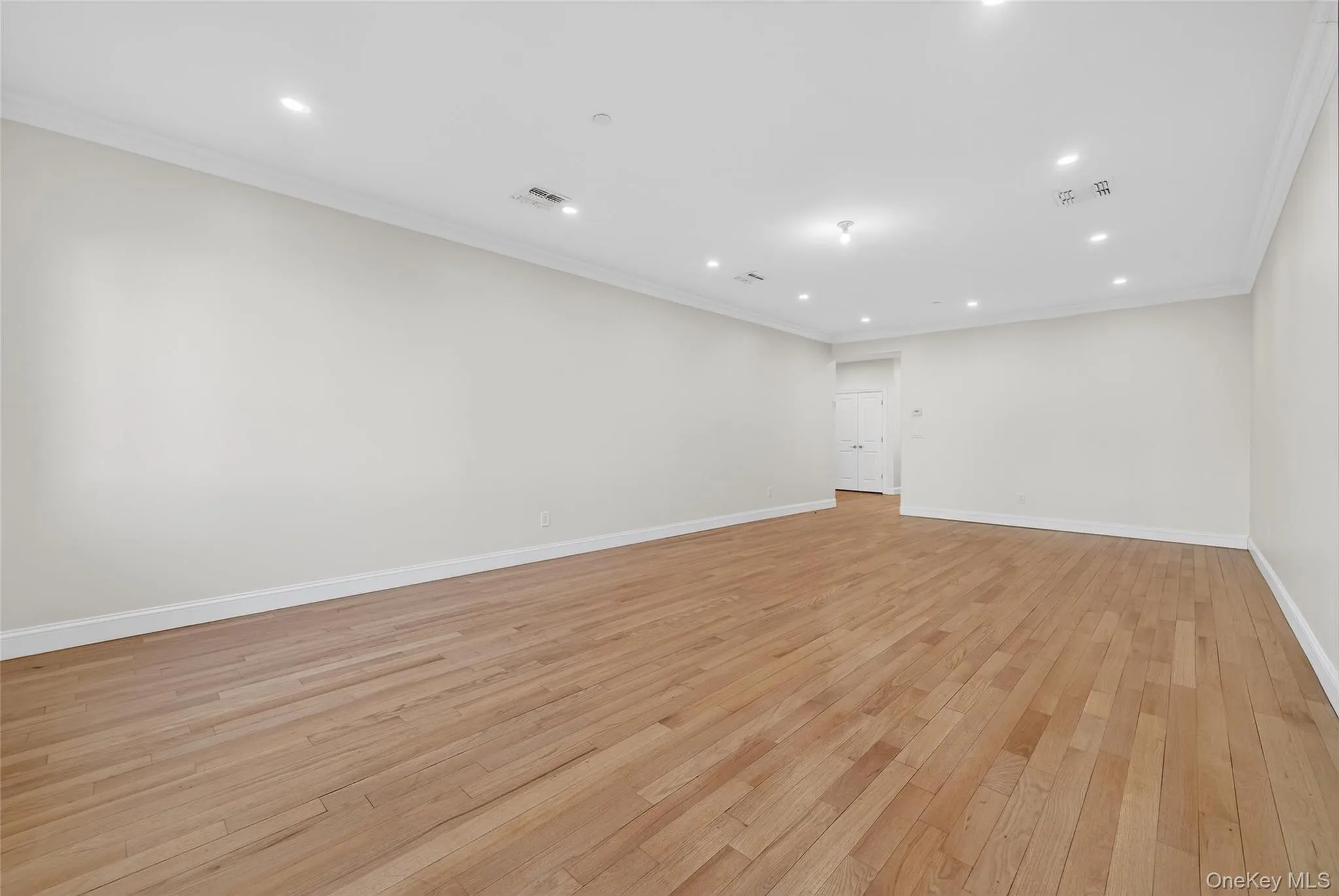 Unfurnished room featuring recessed lighting, ornamental molding, and light wood-style floors Unfurnished room featuring recessed lighting, ornamental molding, and light wood-style floors