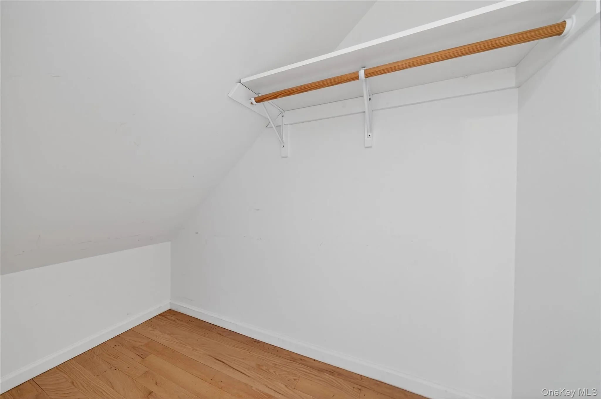 Spacious closet with lofted ceiling and hardwood / wood-style flooring Spacious closet with lofted ceiling and hardwood / wood-style flooring