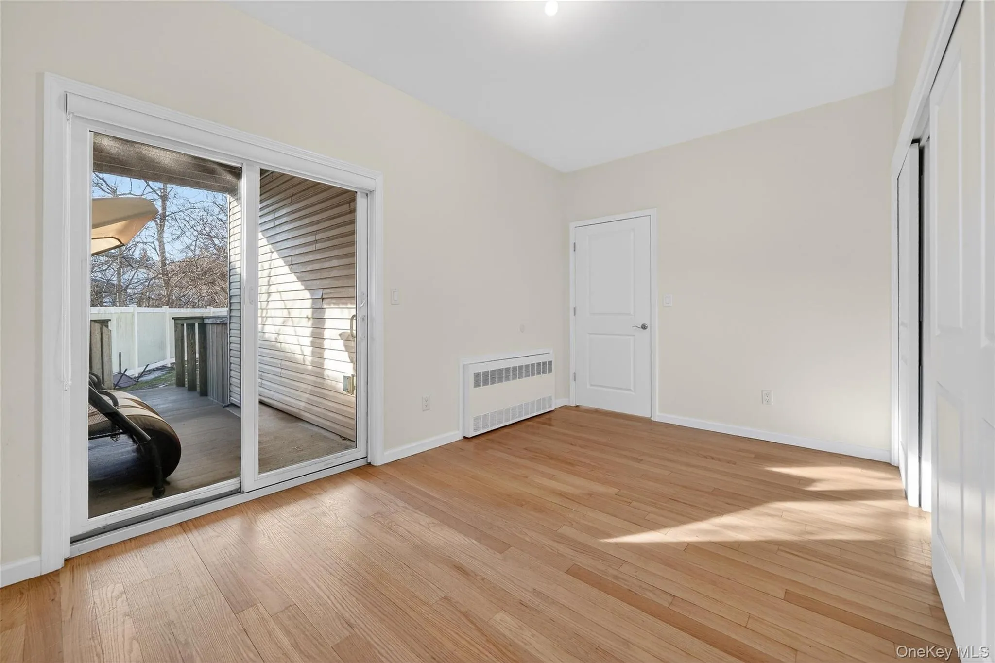 Unfurnished room with light wood-style flooring and radiator heating unit Unfurnished room with light wood-style flooring and radiator heating unit