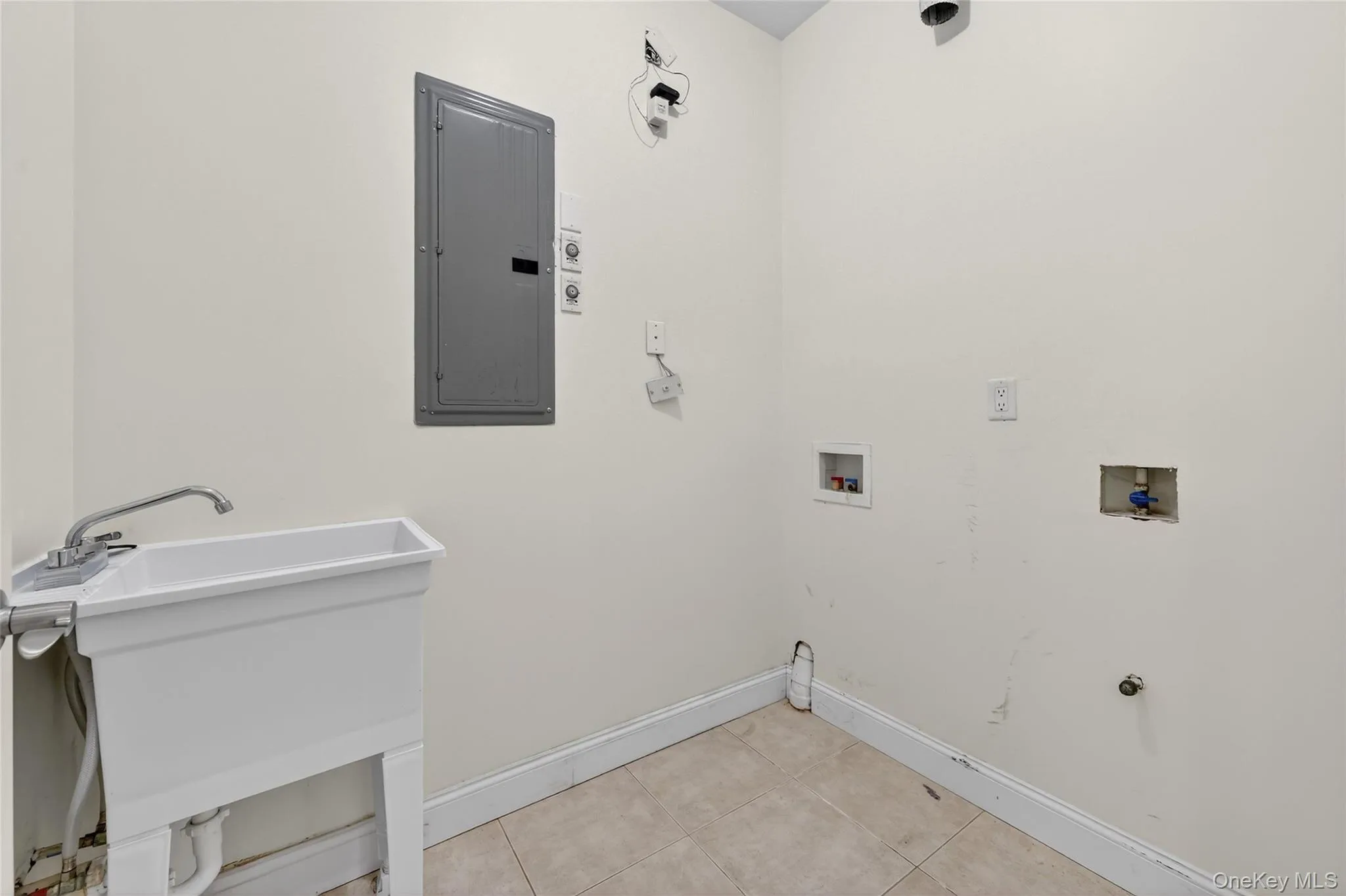 Laundry room with washer hookup, electric panel, light tile patterned flooring, and hookup for a gas dryer Laundry room with washer hookup, electric panel, light tile patterned flooring, and hookup for a gas dryer