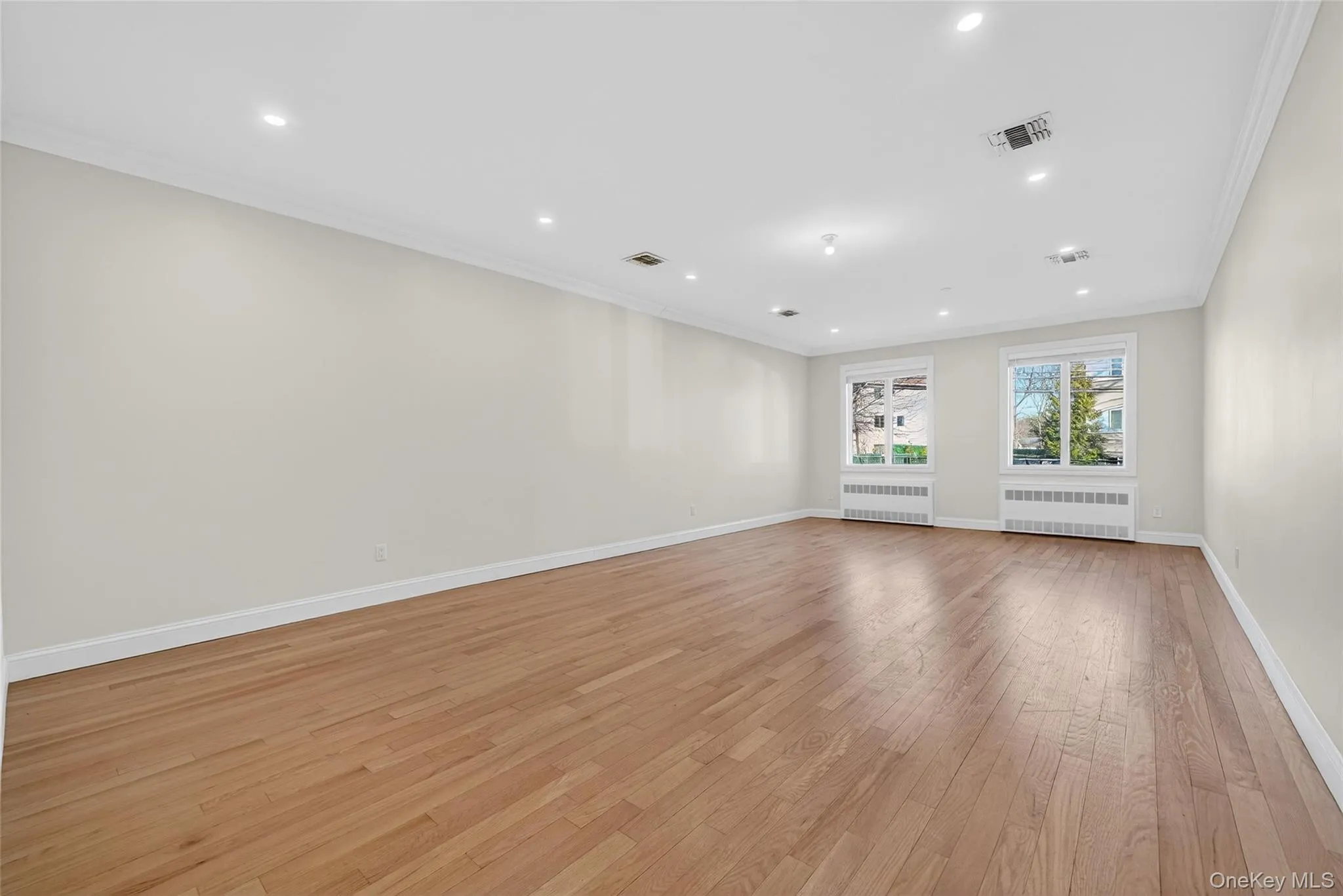 Dining Room featuring ornamental molding, recessed lighting, radiator, and light wood finished floors Dining Room featuring ornamental molding, recessed lighting, radiator, and light wood finished floors