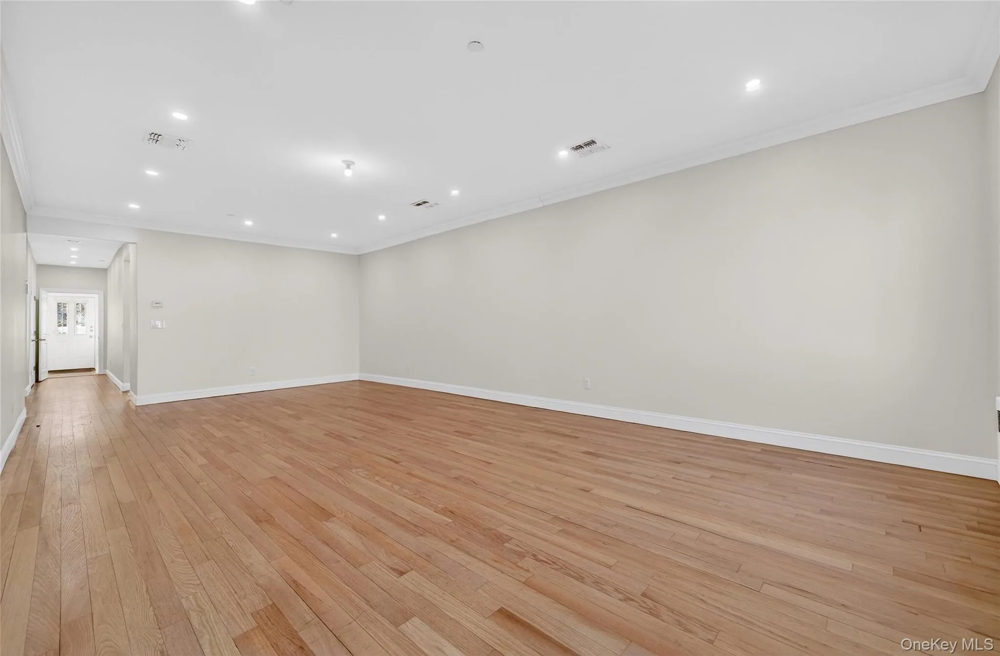 Empty room featuring ornamental molding, recessed lighting, and light wood finished floors Empty room featuring ornamental molding, recessed lighting, and light wood finished floors