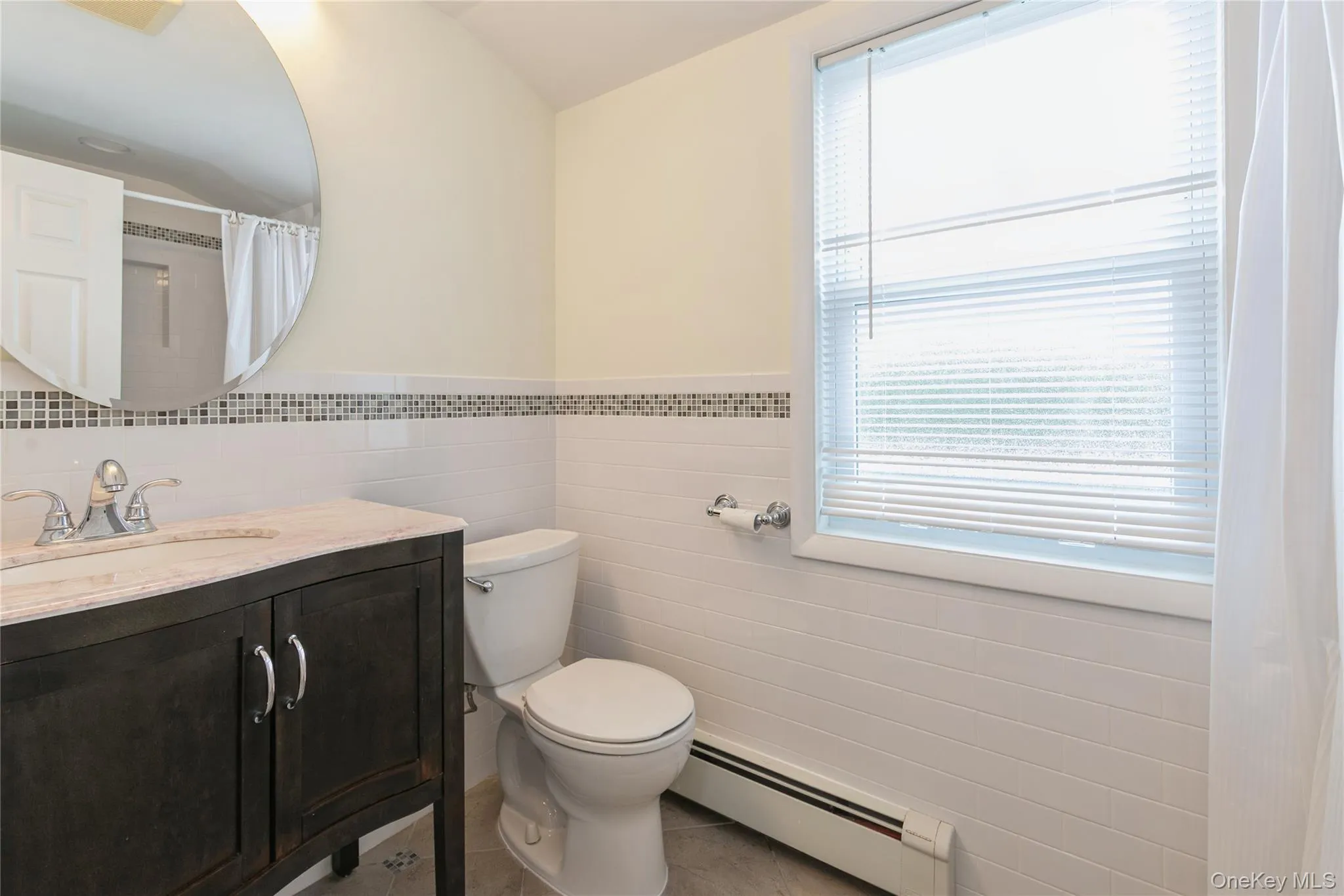 Updated full bathroom featuring a modern vanity, tiled shower with a new tub, and a bright window for natural light. Updated full bathroom featuring a modern vanity, tiled shower with a new tub, and a bright window for natural light.