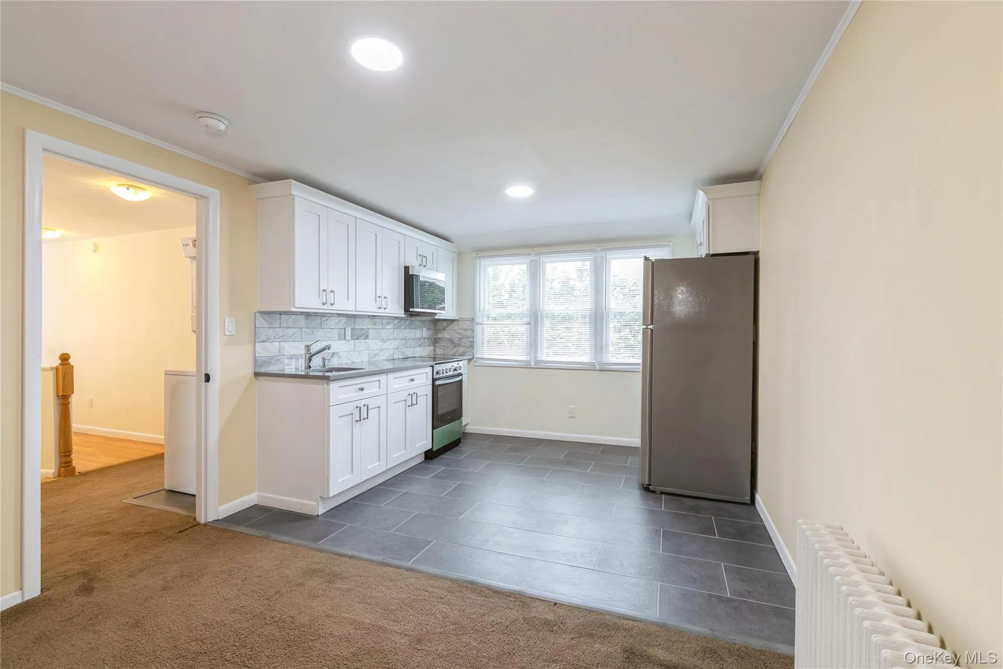 Modern kitchen flows seamlessly into the inviting living area, creating an ideal gathering space. Modern kitchen flows seamlessly into the inviting living area, creating an ideal gathering space.