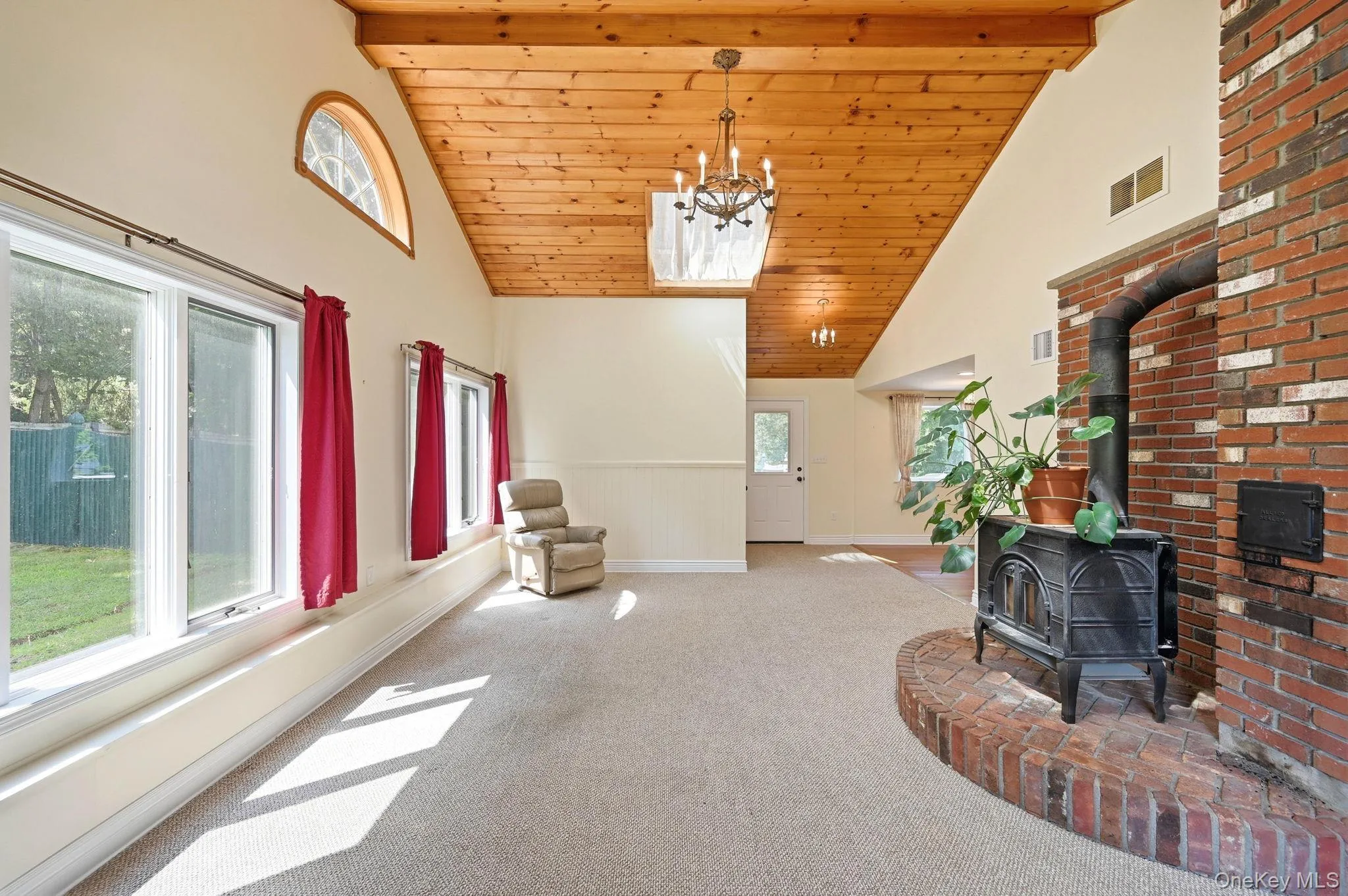 The living room fills with sunshine during the daytime through the large picture windows. The living room fills with sunshine during the daytime through the large picture windows.