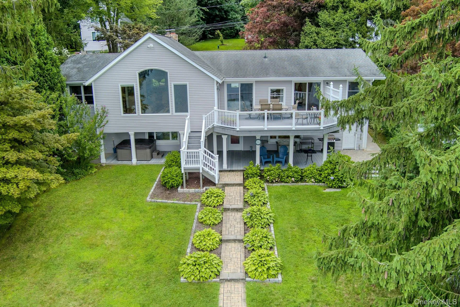 The stunning rear of the home showcases beautiful outdoor living spaces and multiple levels with breathtaking lake views. Lawns for badminton and bocce, a few steps from the lake. The stunning rear of the home showcases beautiful outdoor living spaces and multiple levels with breathtaking lake views. Lawns for badminton and bocce, a few steps from the lake.
